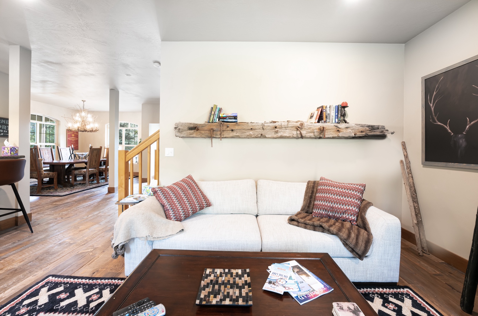 Unwind on your cozy sofa surrounded by rustic charm, where a handcrafted driftwood shelf and warm wood floors create a welcoming retreat that feels like home.