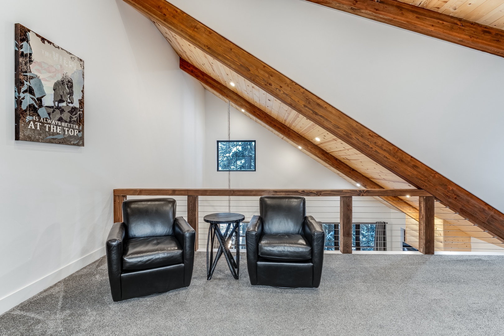 Unwind in your private loft retreat with leather armchairs and rustic beams creating the perfect reading nook.