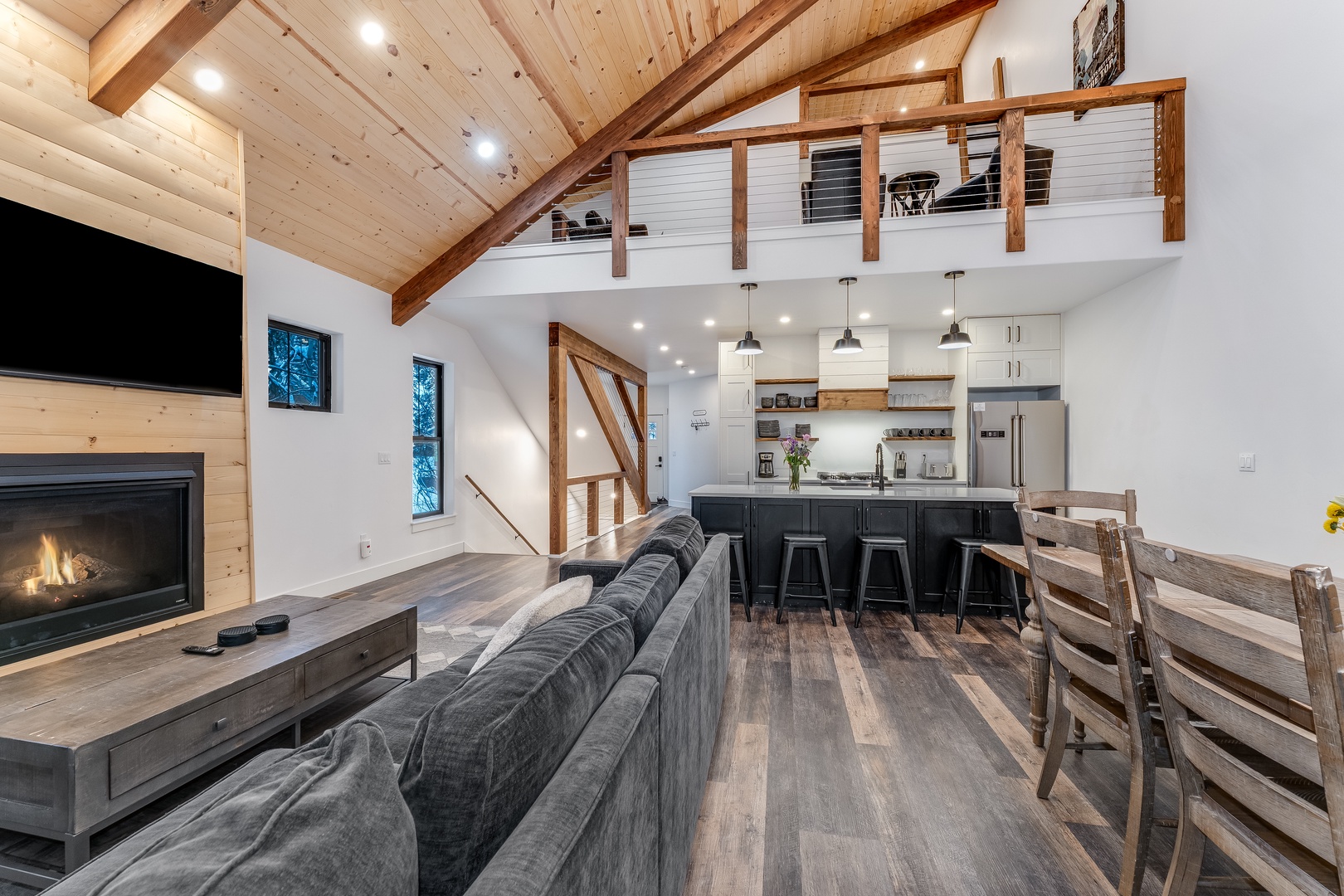 Relax in your cozy living room where exposed beams meet modern comfort, while the crackling fireplace warms memorable evenings together.