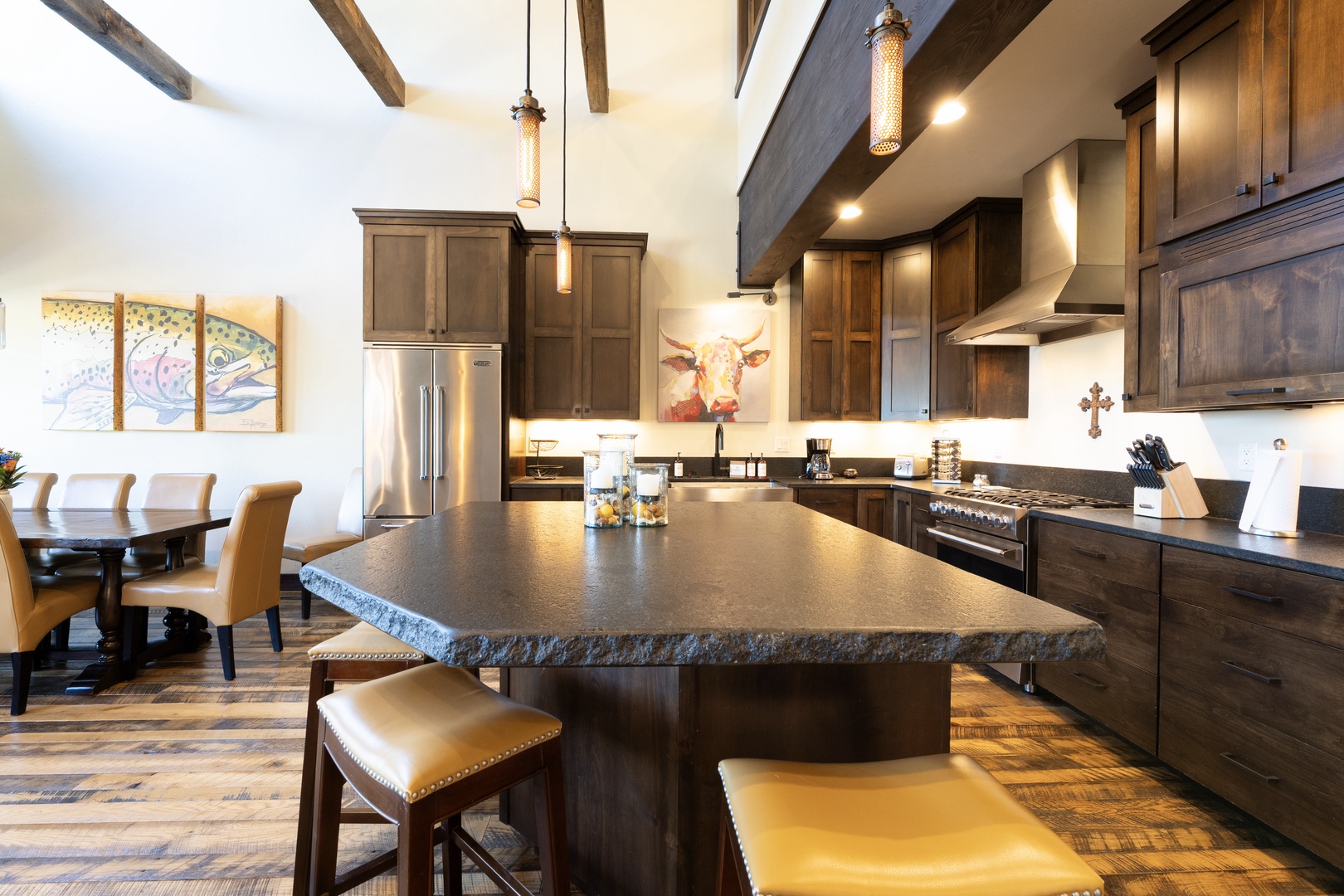Your spacious open-concept kitchen invites you to gather, cook, and share memorable meals together. Rustic wooden beams overhead and rich cabinetry bring warmth, while a generous island anchors the heart of your stay.