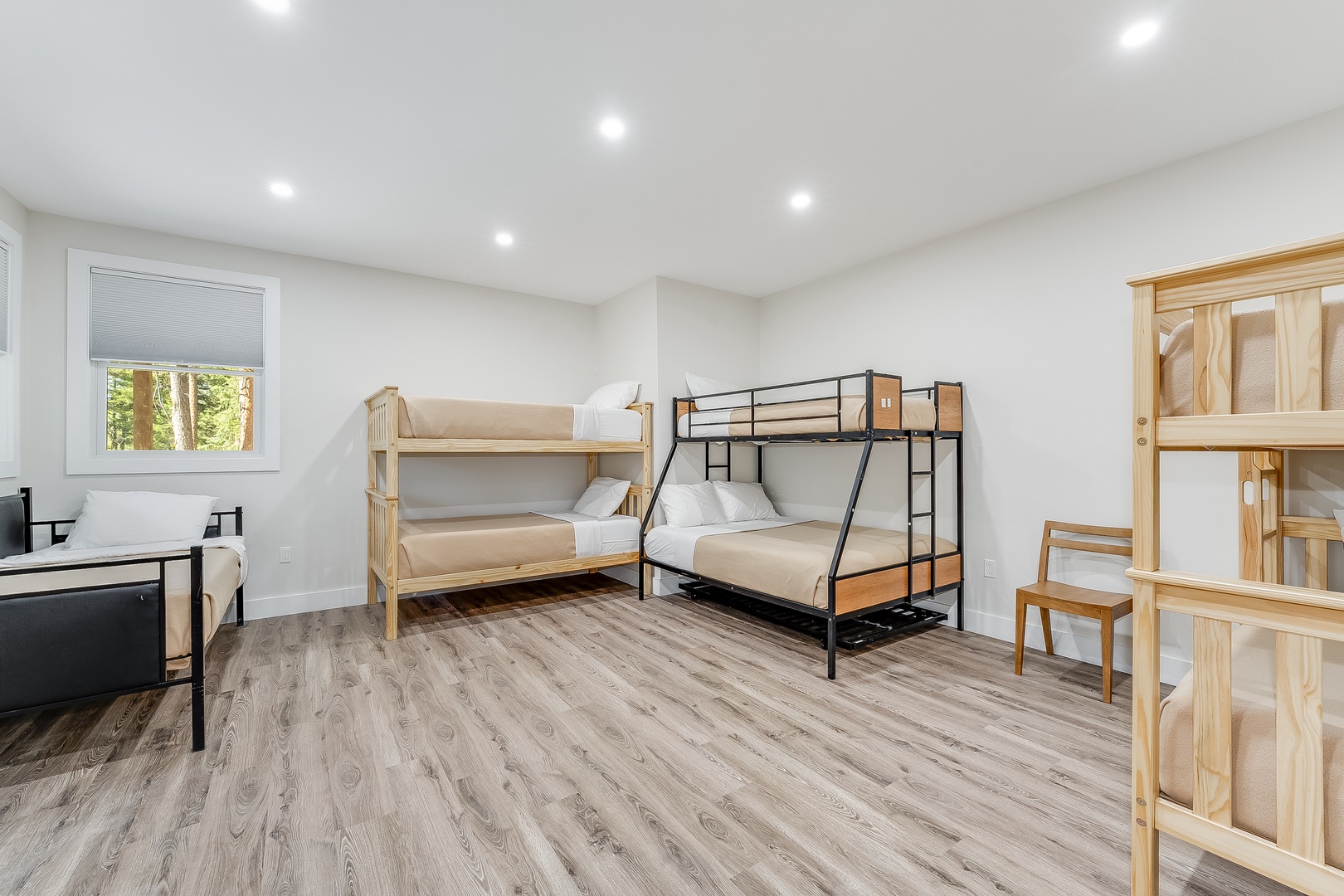 Your group's bedroom offers flexible sleeping with sturdy bunk beds, warm wood tones, and bright recessed lighting, creating a cozy space to rest after a day of adventure.