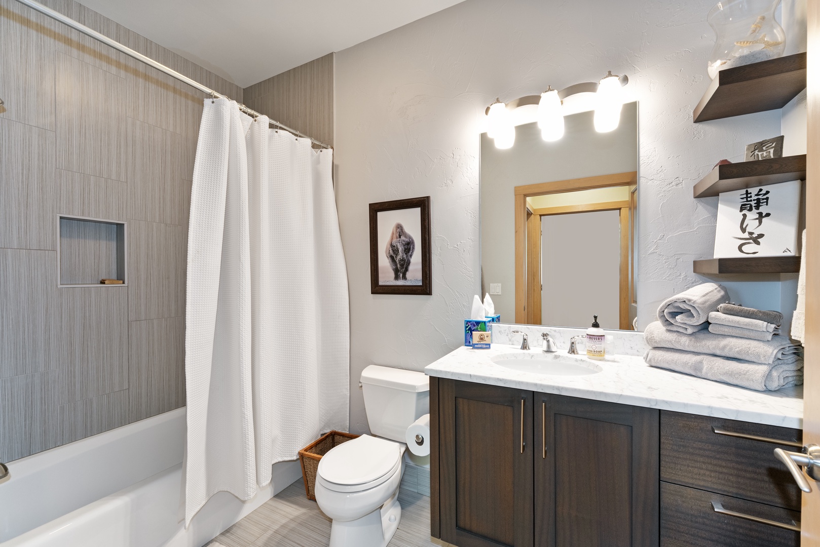 Step into your spa-like bathroom, where crisp white linens await and warm lighting sets a tranquil mood for unwinding after a day of exploration.