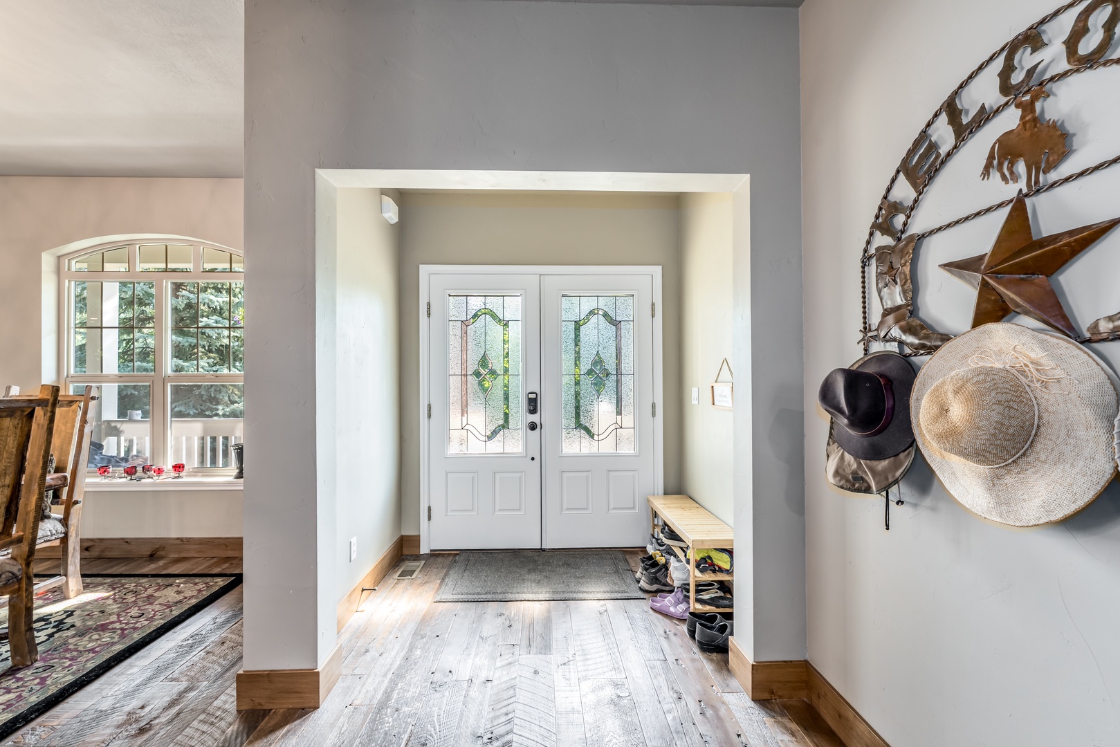 Step inside to find a welcoming entryway with charming stained-glass doors and light wood floors that flow through the home, setting a warm and inviting tone for your stay.