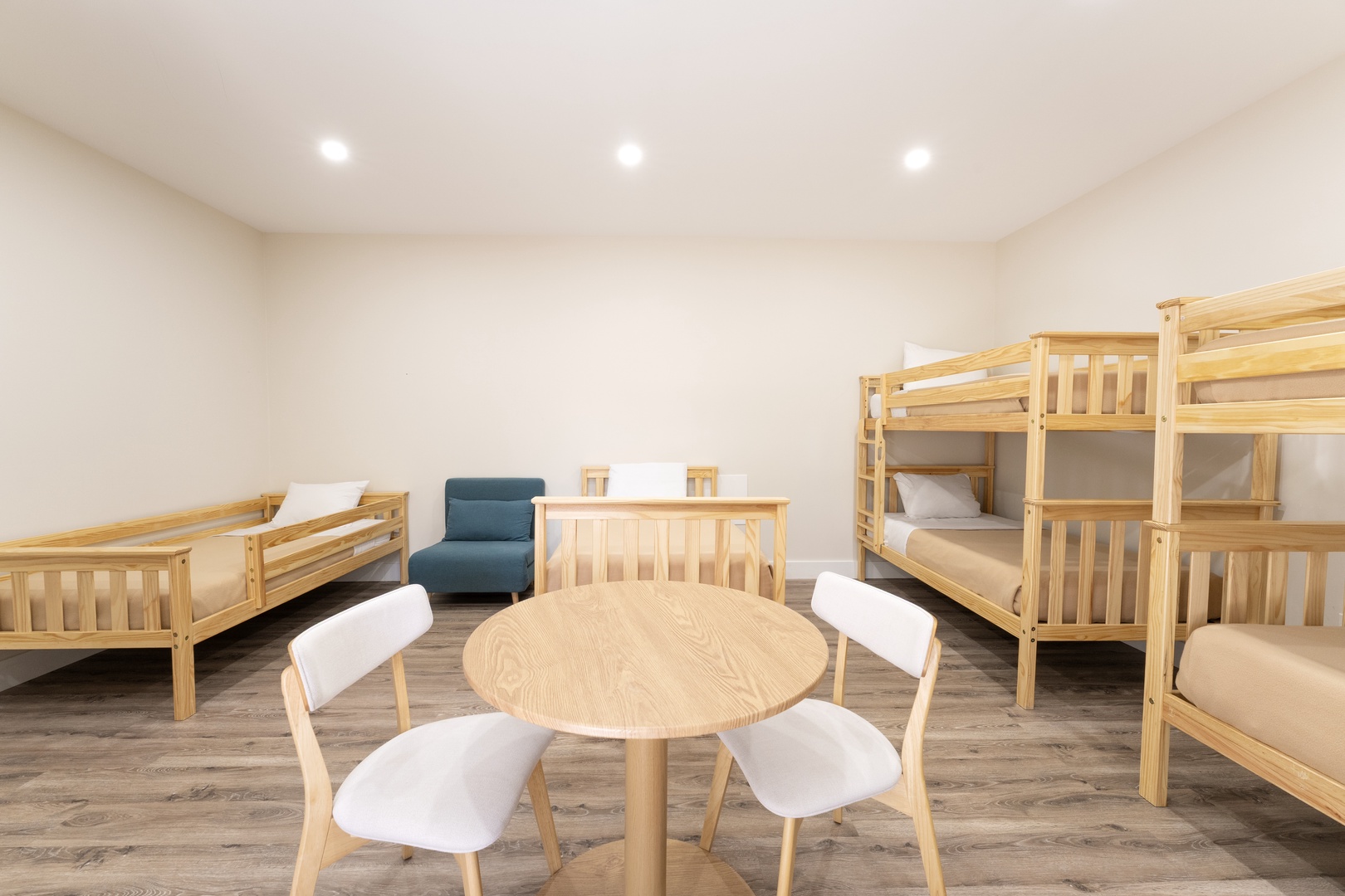 This bright dormitory-style room features cozy bunk beds and a shared dining table, perfect for families or groups traveling together seeking comfort and connection.