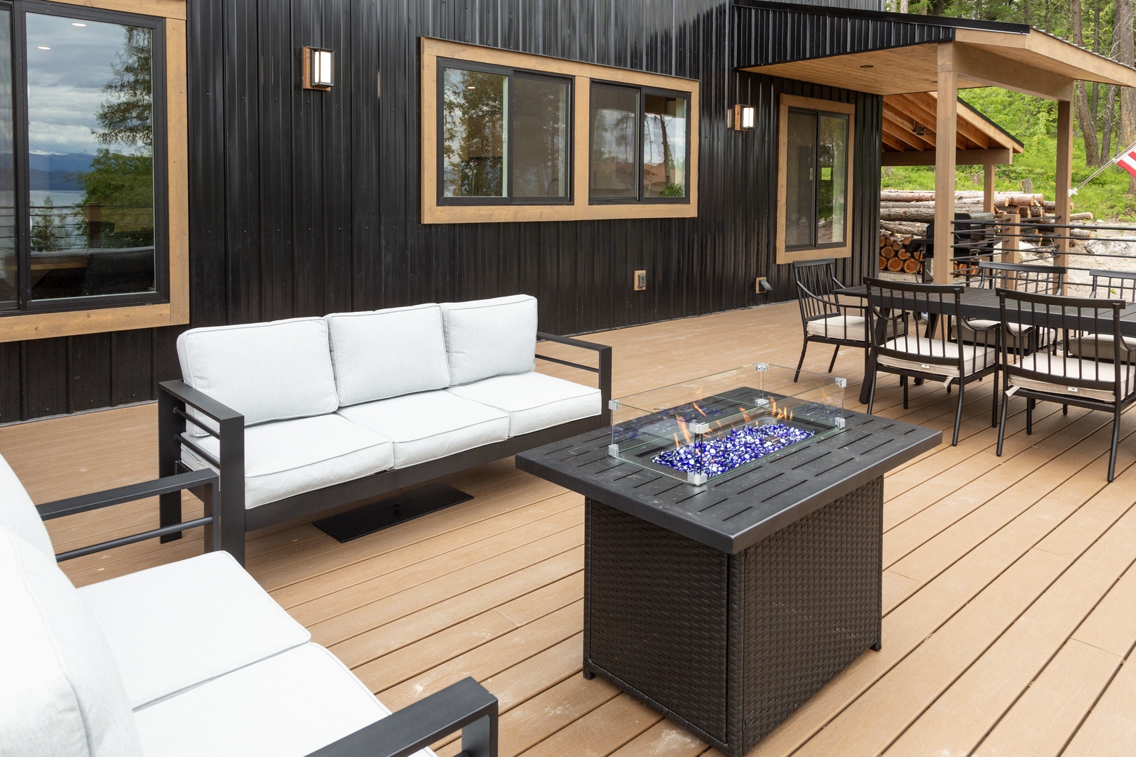 Your private outdoor oasis features a stylish fire pit surrounded by plush seating, perfect for evenings under the stars with mountain and lake views framing your retreat.