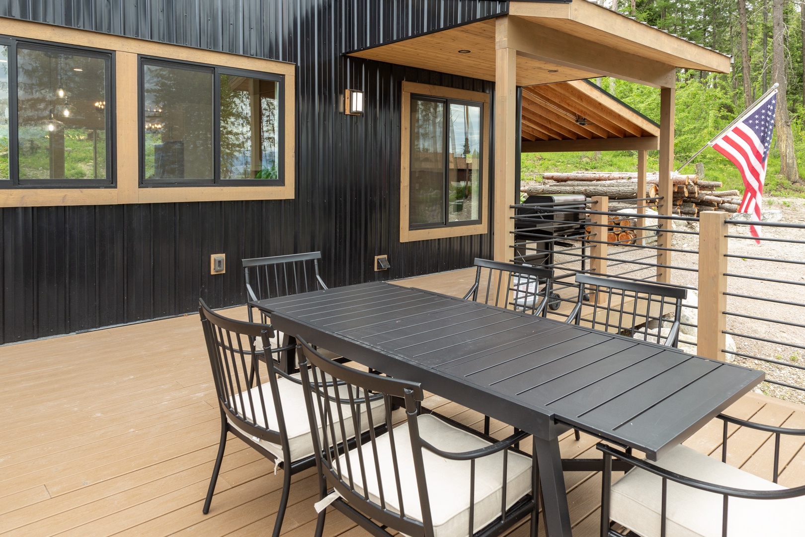 Relax on your private deck with seating for outdoor dining, shaded by a modern overhang. Surrounded by forest, it's your peaceful retreat.