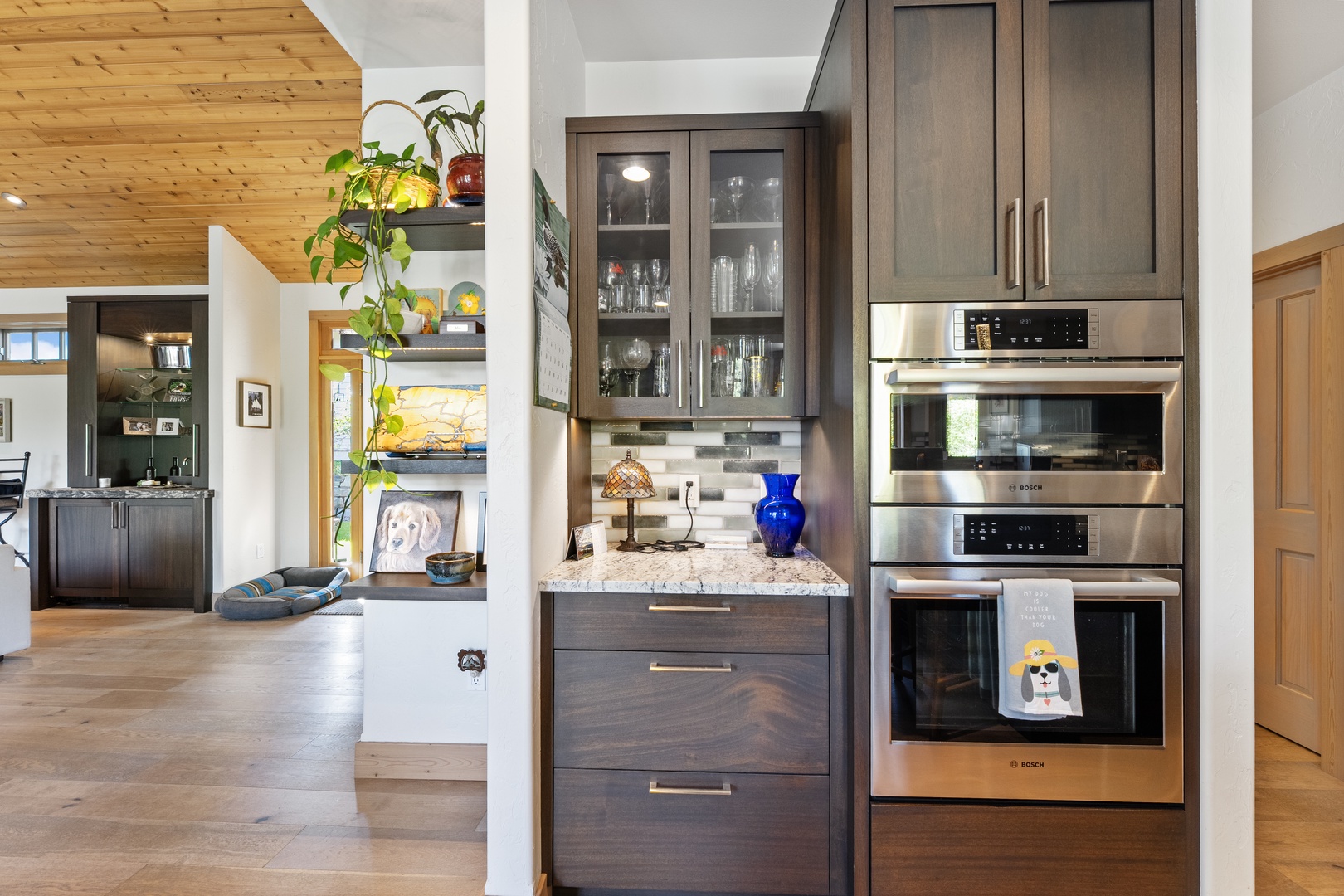 A fully equipped kitchen awaits with sleek stainless steel appliances, including a built-in double oven and microwave, alongside elegant dark wood cabinetry and granite countertops perfect for preparing your favorite meals.