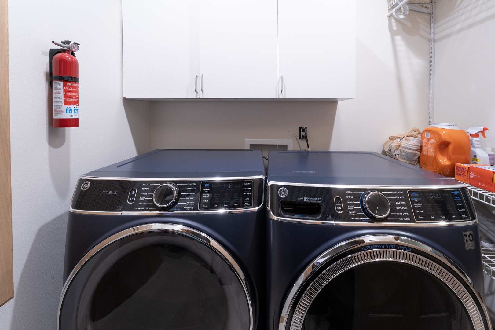 Modern front-load washer and dryer in your dedicated laundry space, with ample cabinet storage overhead for all your supplies.