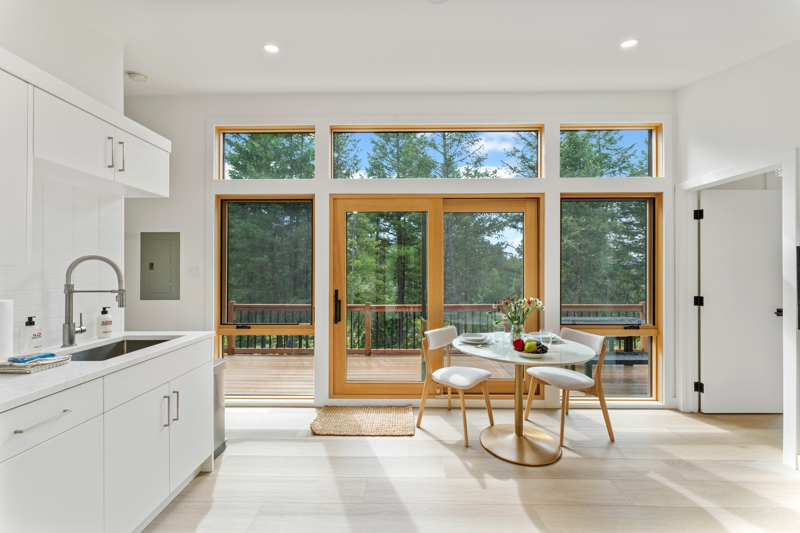 Imagine sipping your morning coffee at this sun-drenched breakfast nook, where floor-to-ceiling windows frame lush forest views and your private deck invites you to breathe in fresh mountain air.