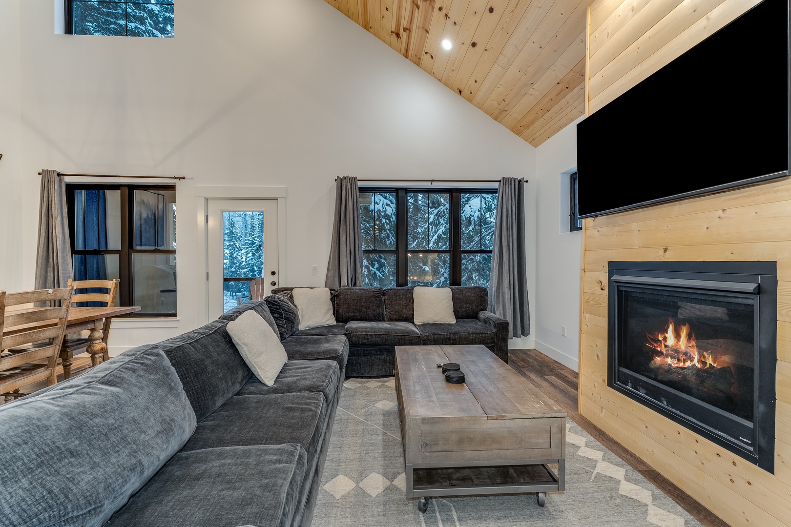 Cozy up by the crackling fireplace in your spacious living room, where plush sofas and warm wood accents create the perfect alpine retreat.