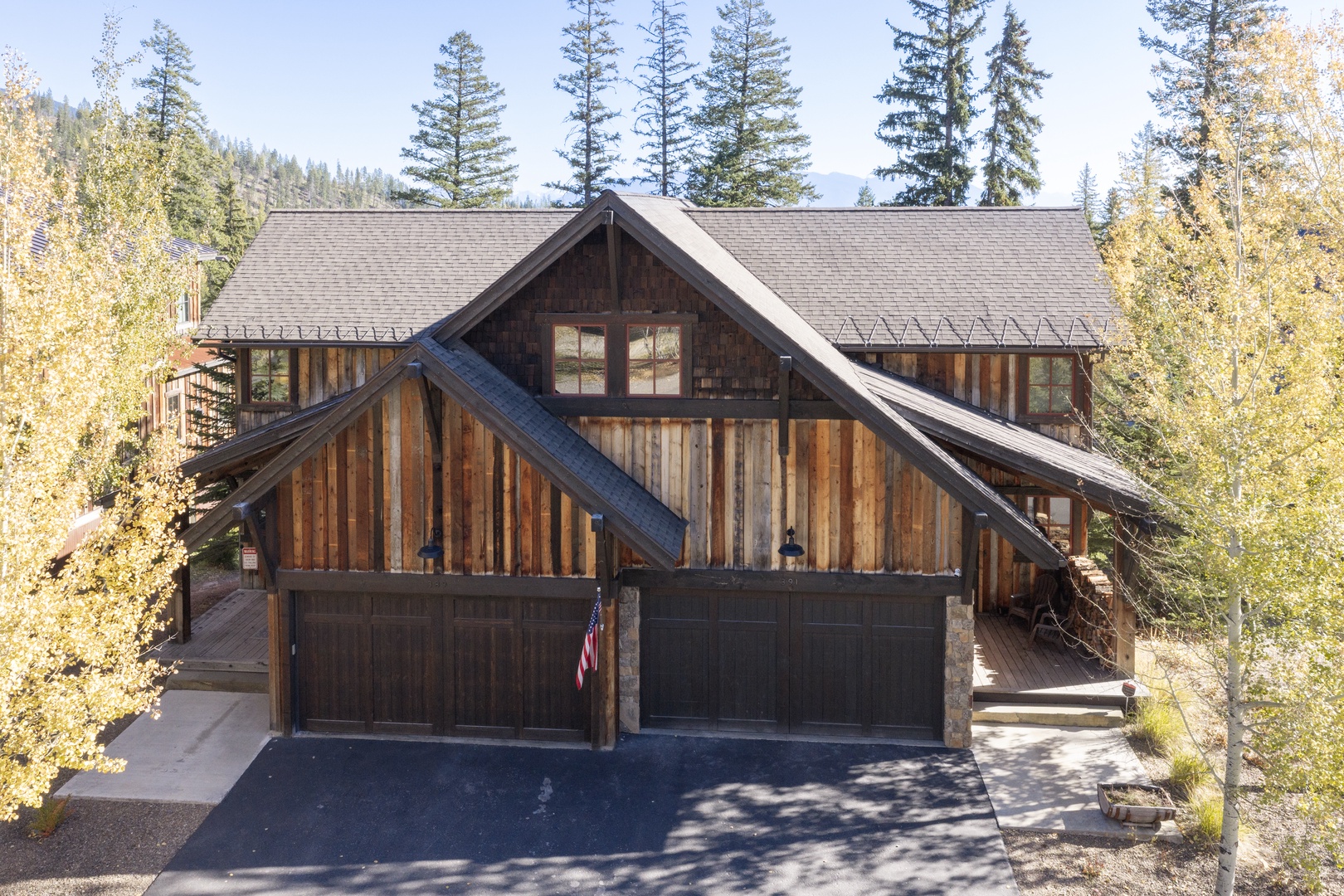 Rustic mountain cabin nestled among towering pines and golden aspens, with spacious parking in a tranquil wooded setting.
