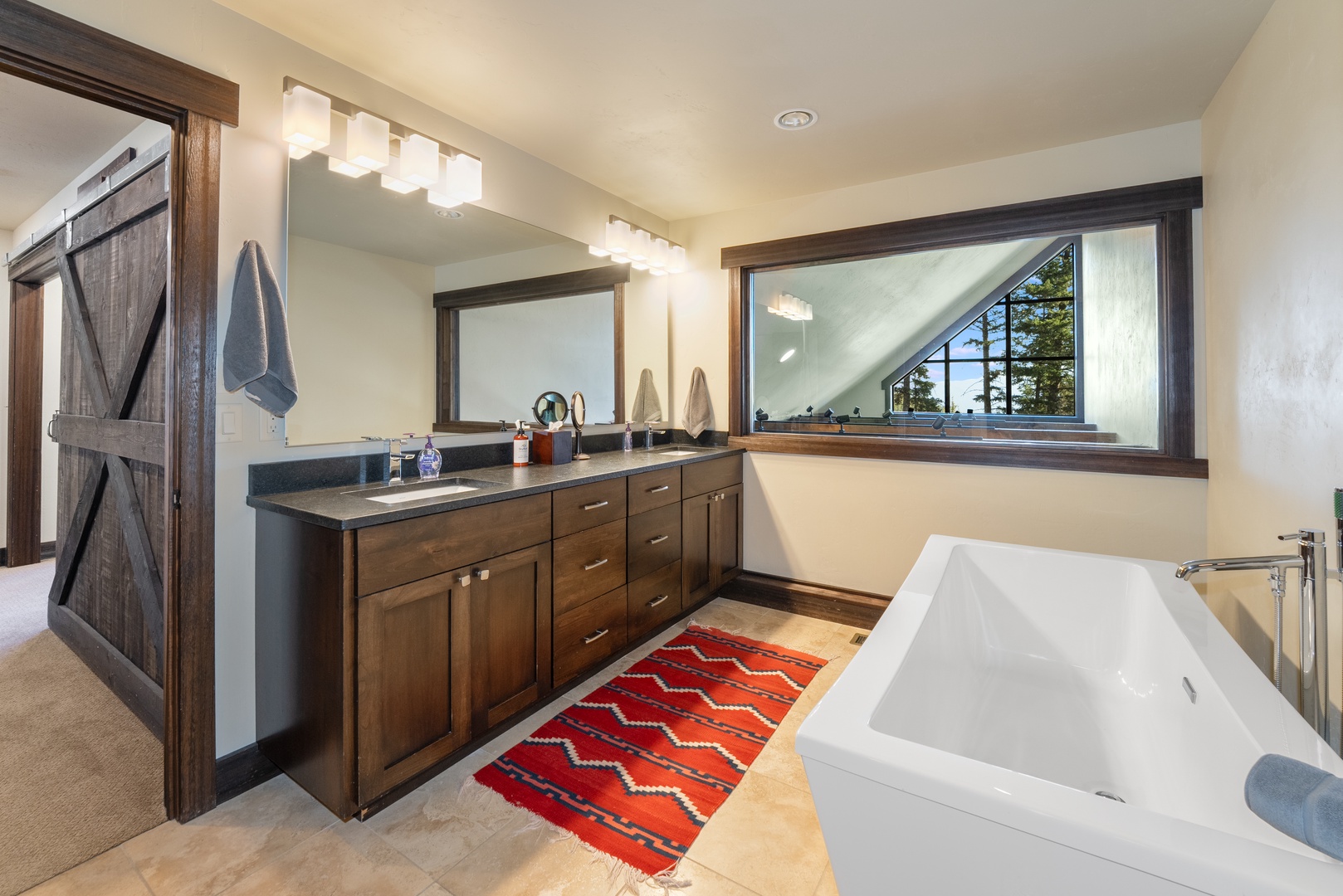 Soak away your cares in the deep soaking tub or freshen up at your spacious dual vanity, all while natural light pours in from the window above.