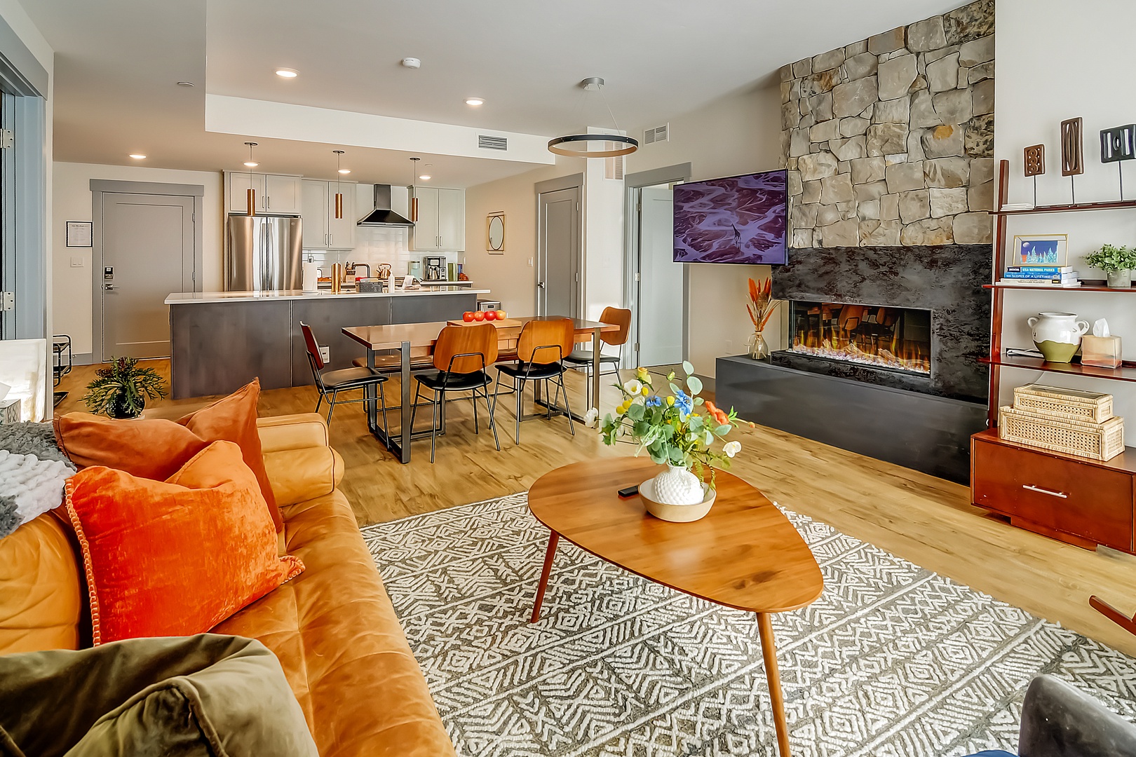 Relax in your stylish open-plan haven featuring a cozy fireplace, modern kitchen, and inviting living space perfect for memorable evenings.