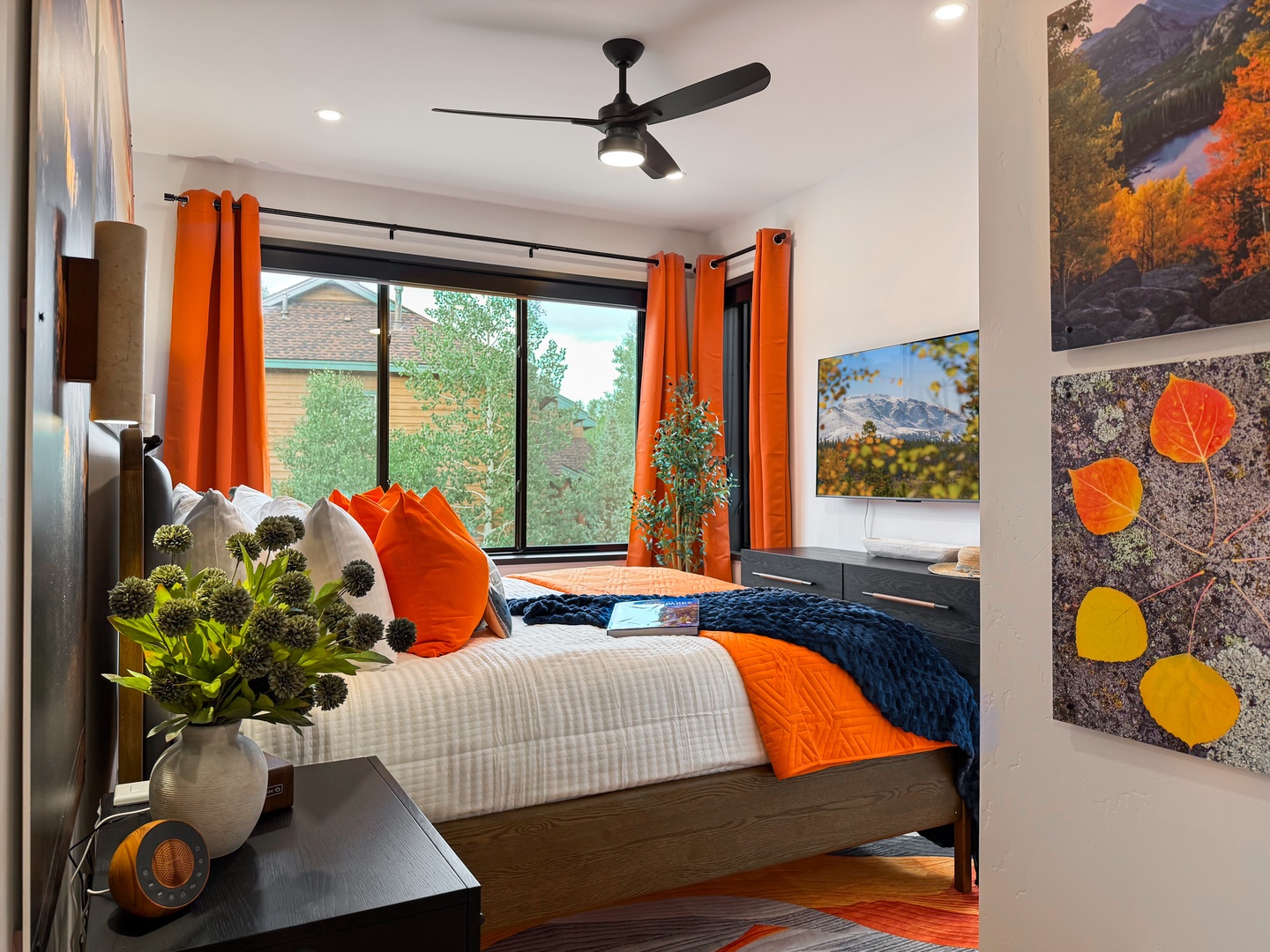 Settle into your cozy retreat with cheerful pops of orange and a plush bed that invites restful nights. Natural light pours through large windows, while thoughtful décor and fresh flowers add warmth to your mountain getaway.