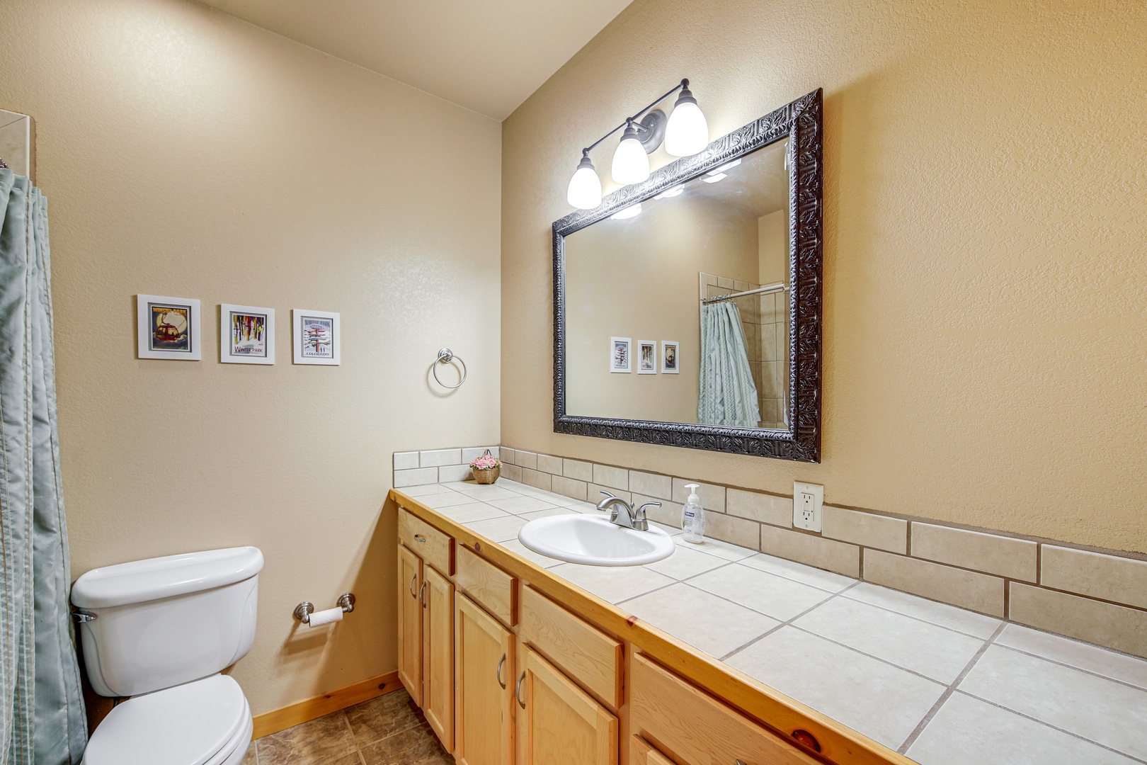 Your private bathroom features warm wood cabinets, elegant tile countertops, and thoughtful touches that make your morning routine feel like a retreat.