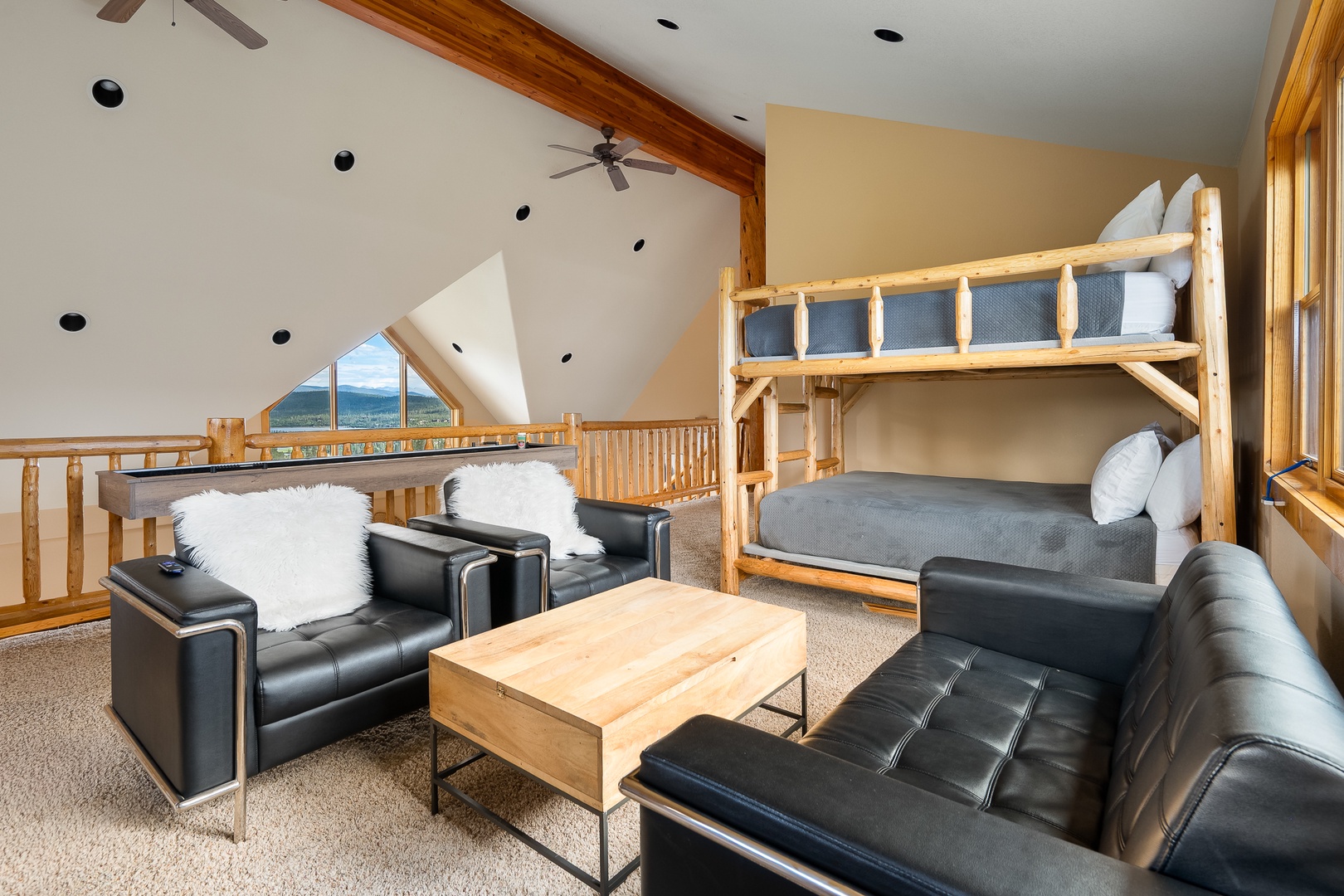 Relax in your cozy loft featuring custom bunk beds and plush seating, all framed by vaulted ceilings and stunning mountain views through expansive windows.