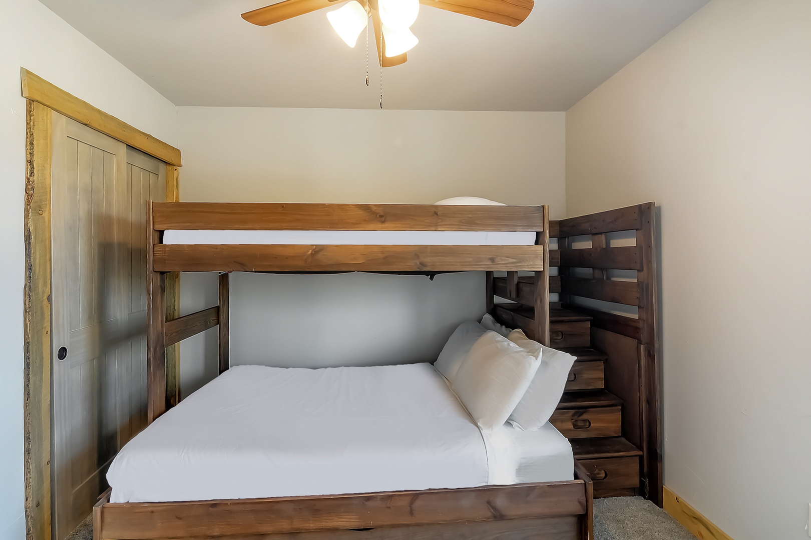 Your cozy bunk room features sturdy wooden beds with crisp white linens, perfect for families or groups seeking comfortable shared accommodations.