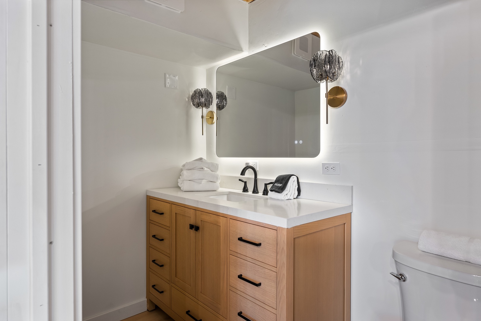 Step into your bright, modern bathroom with elegant fixtures, a backlit mirror, and plush towels waiting for you—a calm retreat to refresh at day's start or end.