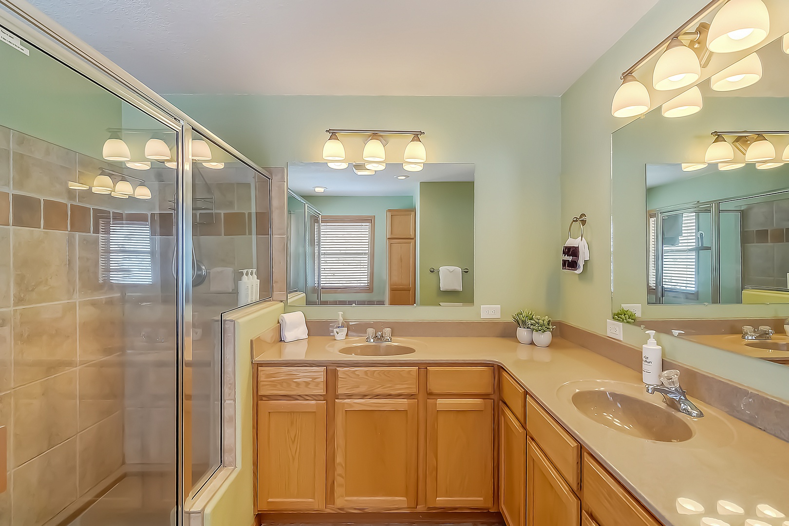 Unwind in your spacious bathroom featuring dual vanities, elegant lighting, and a tiled shower—perfect for refreshing after your adventures.