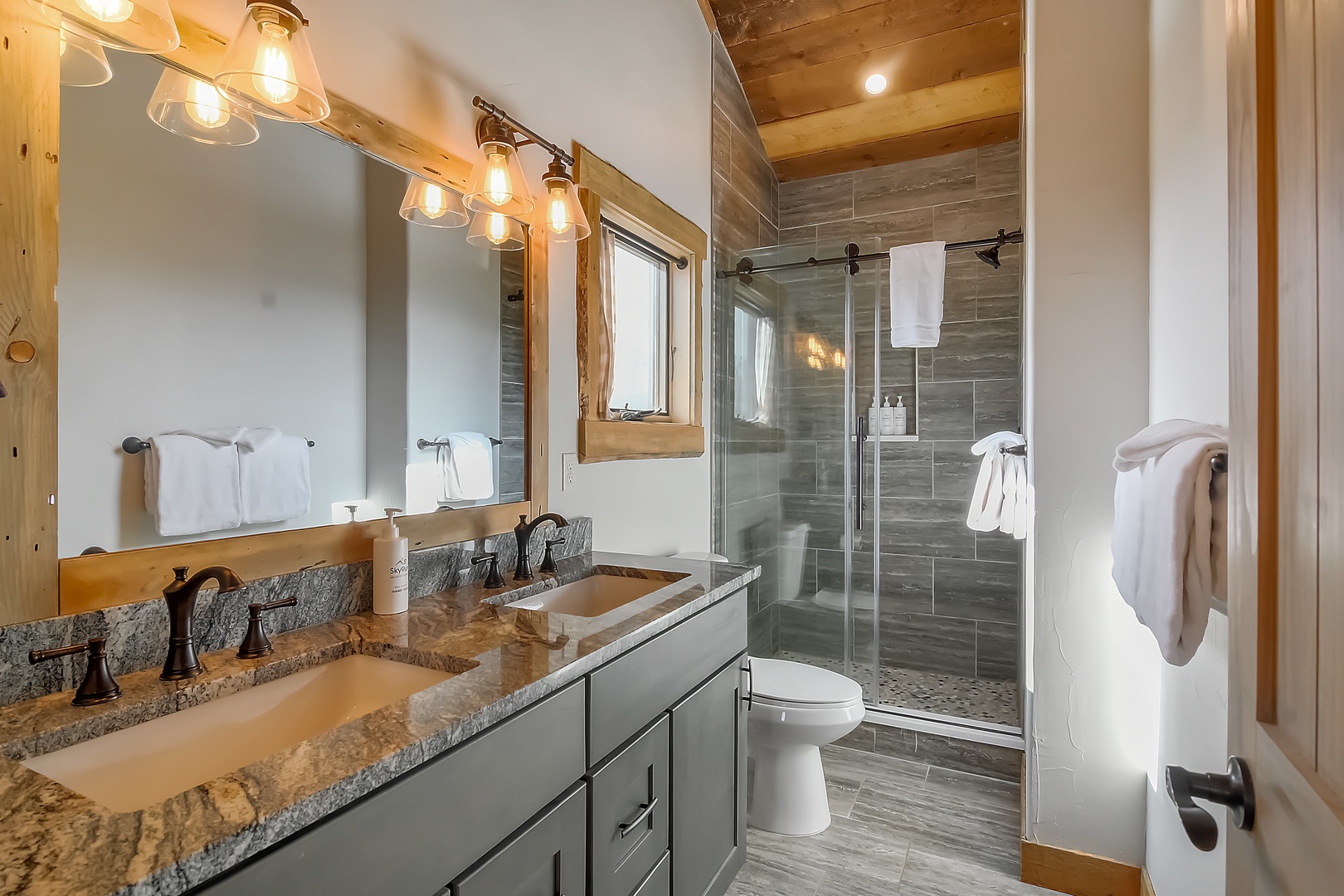 Your spa-like ensuite features warm wood accents and granite counters, creating the perfect retreat after mountain adventures.