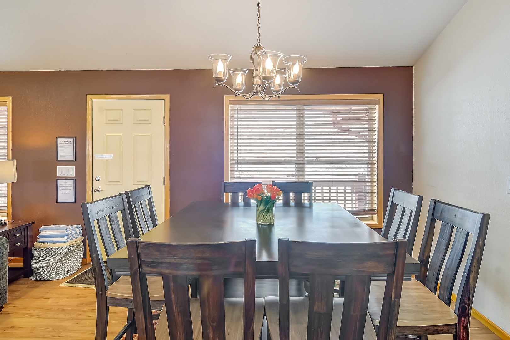 Gather around your elegant dining table where warm chandelier light creates the perfect atmosphere for memorable meals together.