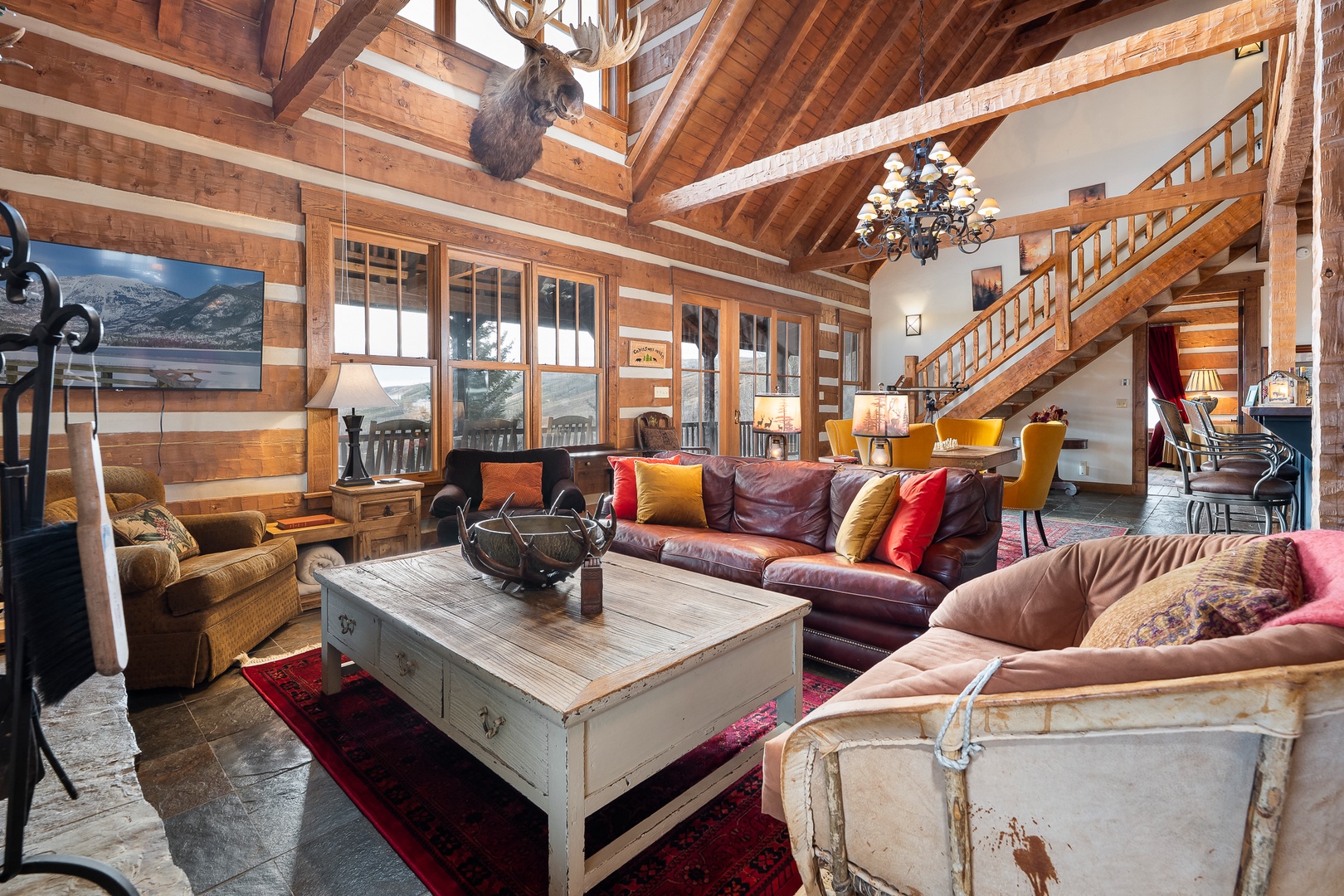Relax in your rustic mountain lodge with soaring timber beams, warm alpine charm throughout this spacious living area.