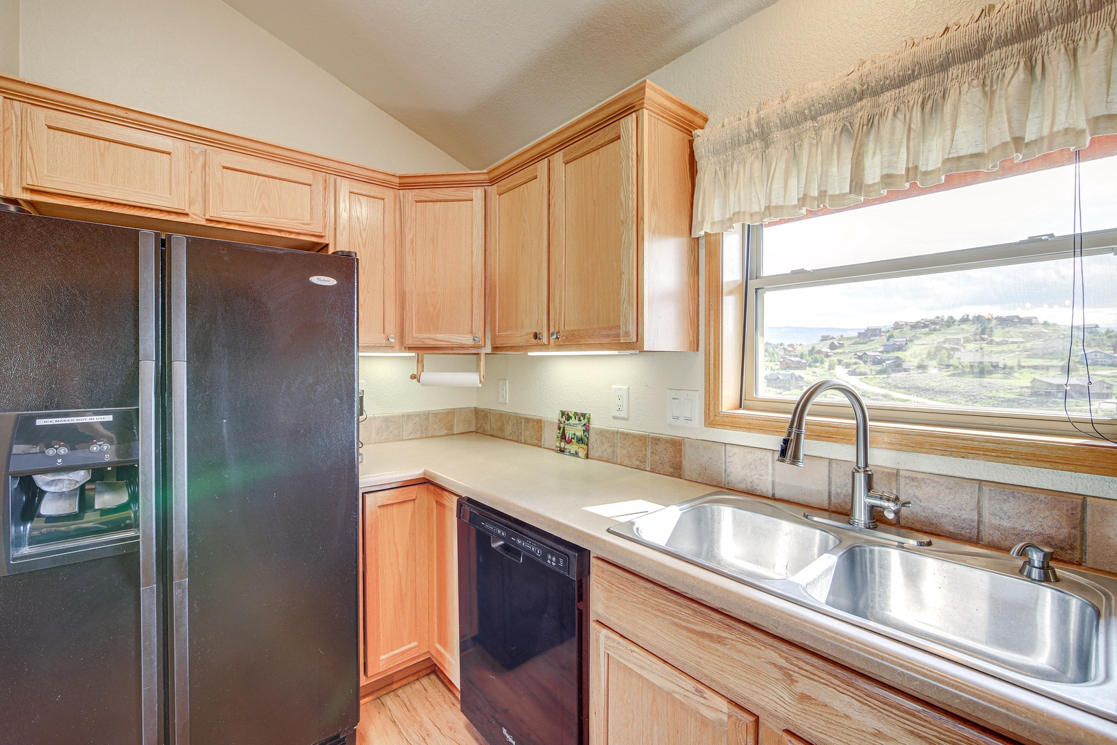 Your fully equipped kitchen features warm wood cabinets and scenic rolling hills views while you cook memorable meals.