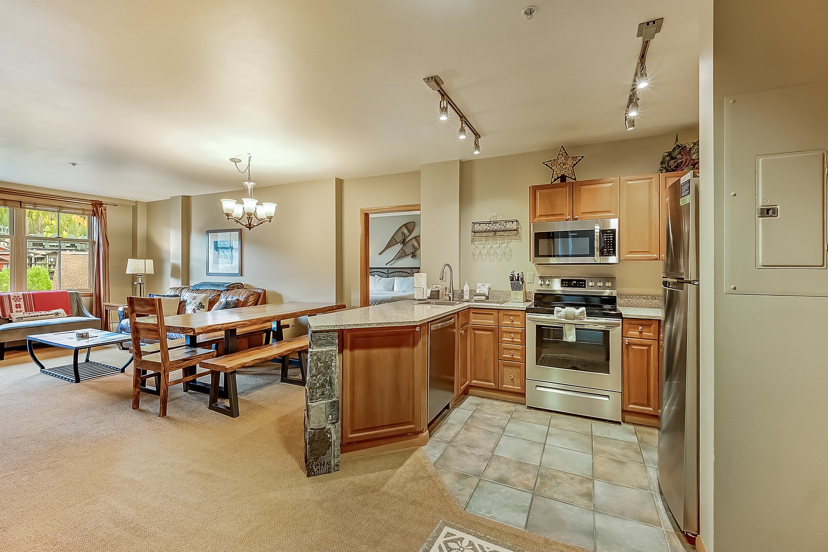Step into your open-concept retreat where the living space flows seamlessly into a fully equipped kitchen. You'll love the natural light streaming through large windows, the warm wood tones, and room to unwind or cook a memorable meal together.