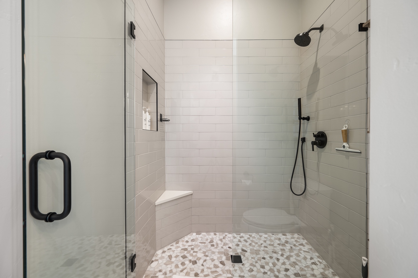 Step into your spa-like shower with sleek glass doors, crisp white subway tile, and a rain showerhead that turns every rinse into a moment of pure relaxation.