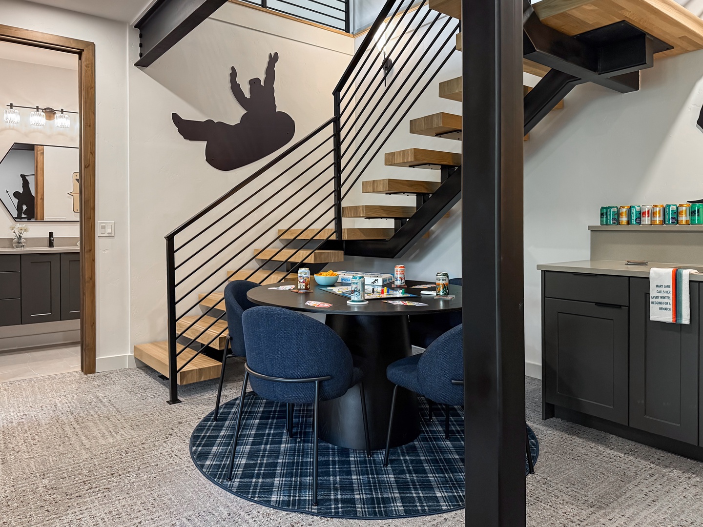 Gather at the stylish dining area beneath striking architectural stairs, where bold design meets your everyday comfort. Modern touches and an open layout make every meal feel special.