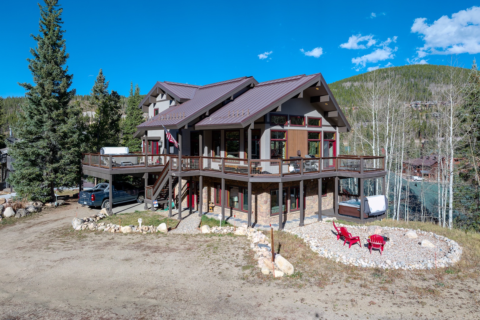 A view of the house with a fire pit, just look at that wrap around deck!