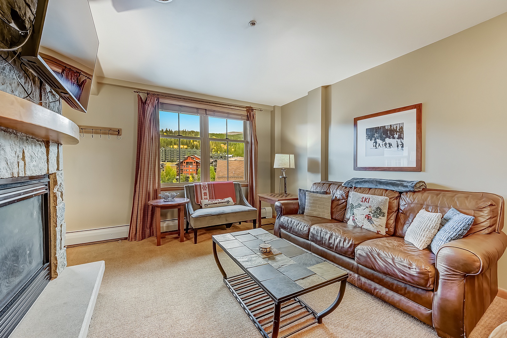 Sink into the plush leather sofa and gaze out at mountain views framed by your living room window. The cozy fireplace and inviting seating create your perfect home base.