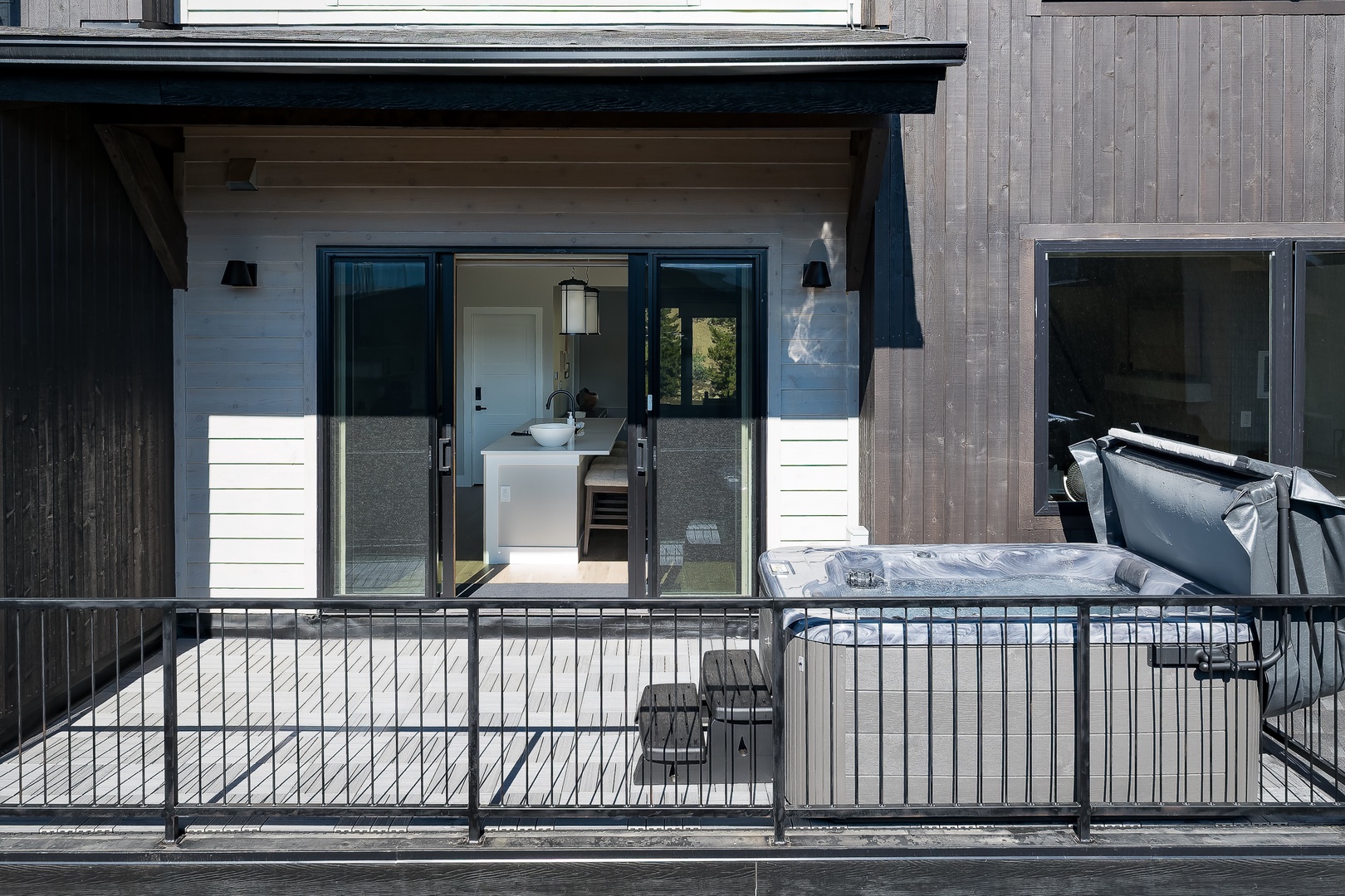 Bright private balcony with seating where you can relax and soak up the sunshine, connected to a modern bathroom just beyond the glass doors.