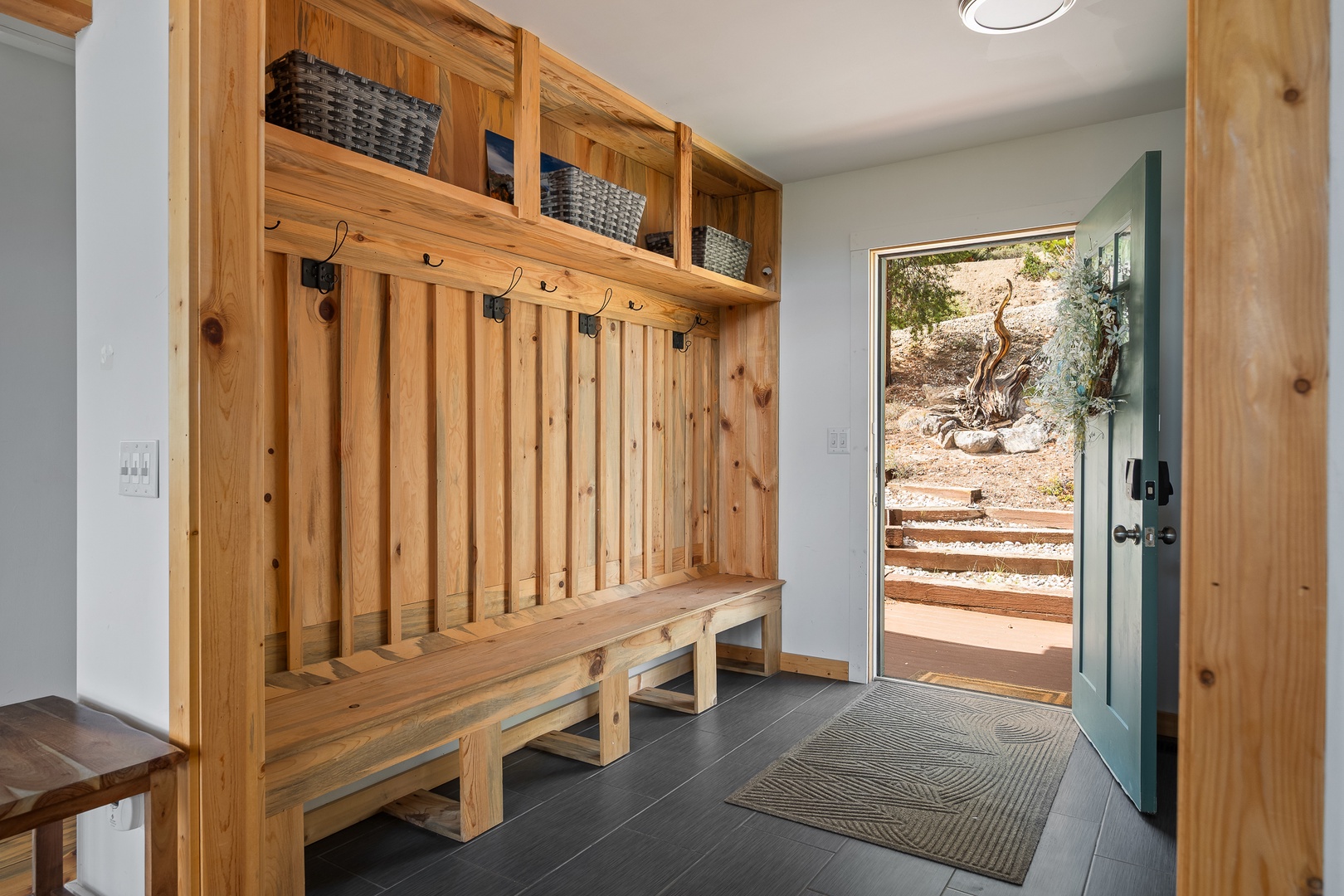 Step into your own private mudroom, where handcrafted wood storage and built-in benches welcome you home after desert adventures.