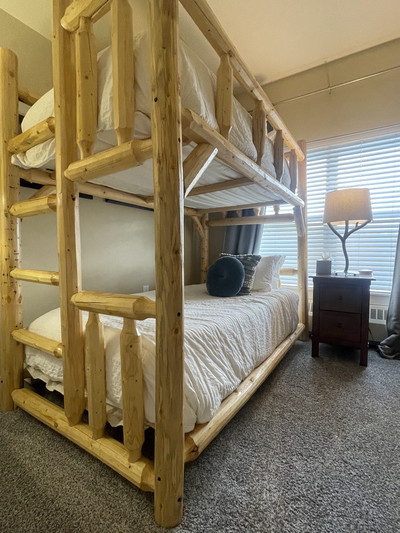 Your cozy bunk bed room features sturdy wooden frames and fresh linens, with a TV for evening entertainment after your adventures.