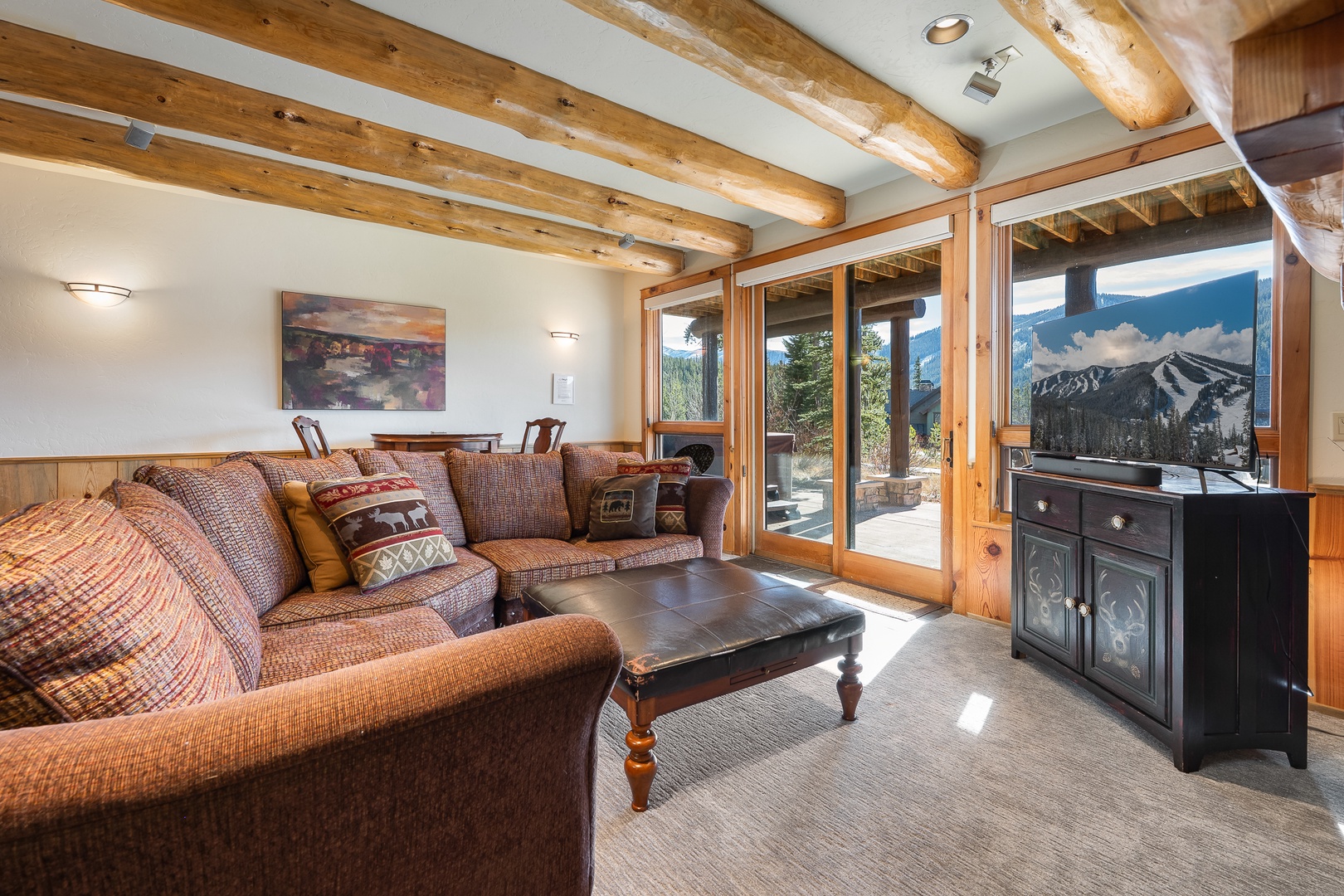 Second Living area downstairs Sink into plush sofas beneath rustic beams while mountain views.