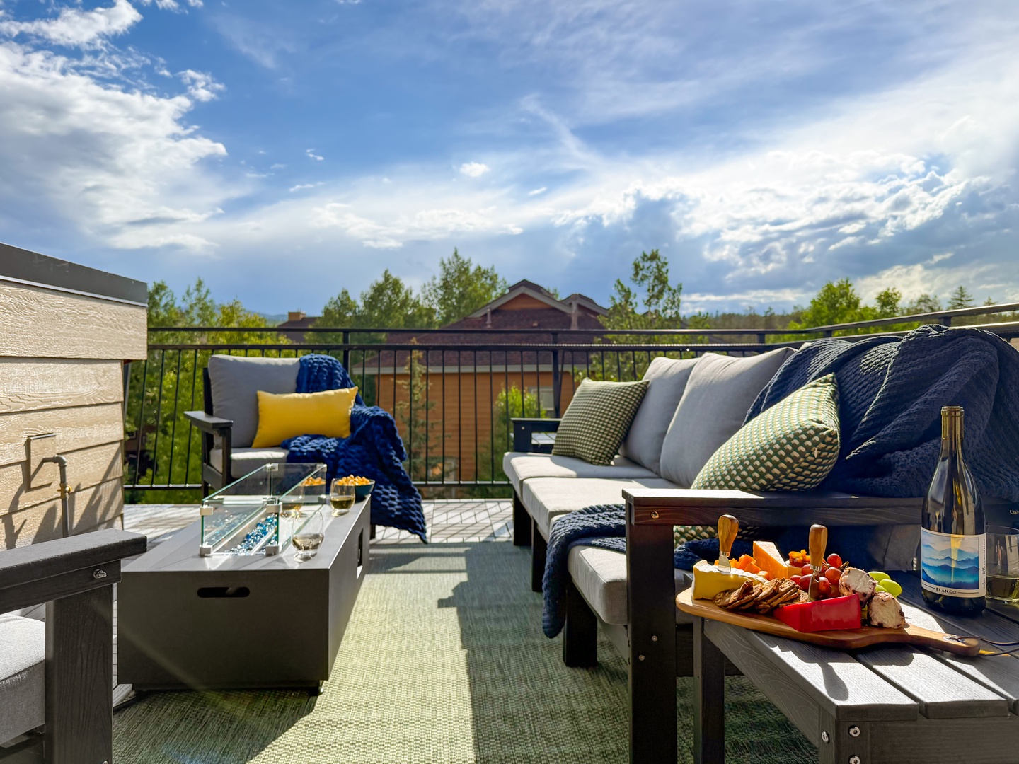 Step onto your private terrace and settle into plush outdoor seating, where charcuterie and wine await beneath open skies. The surrounding treetops and crisp mountain air make every moment here feel like a serene escape.