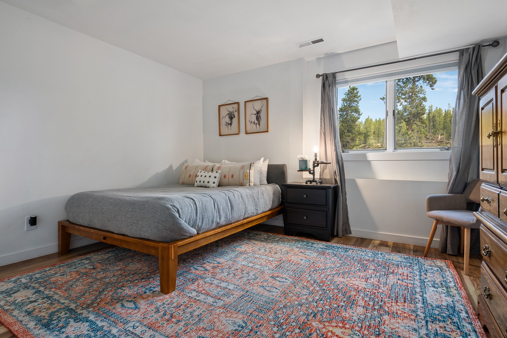 Sunlight pours into your restful bedroom through large windows framing peaceful forest views. Cozy linens and warm wood tones create the perfect retreat after a day of adventure.