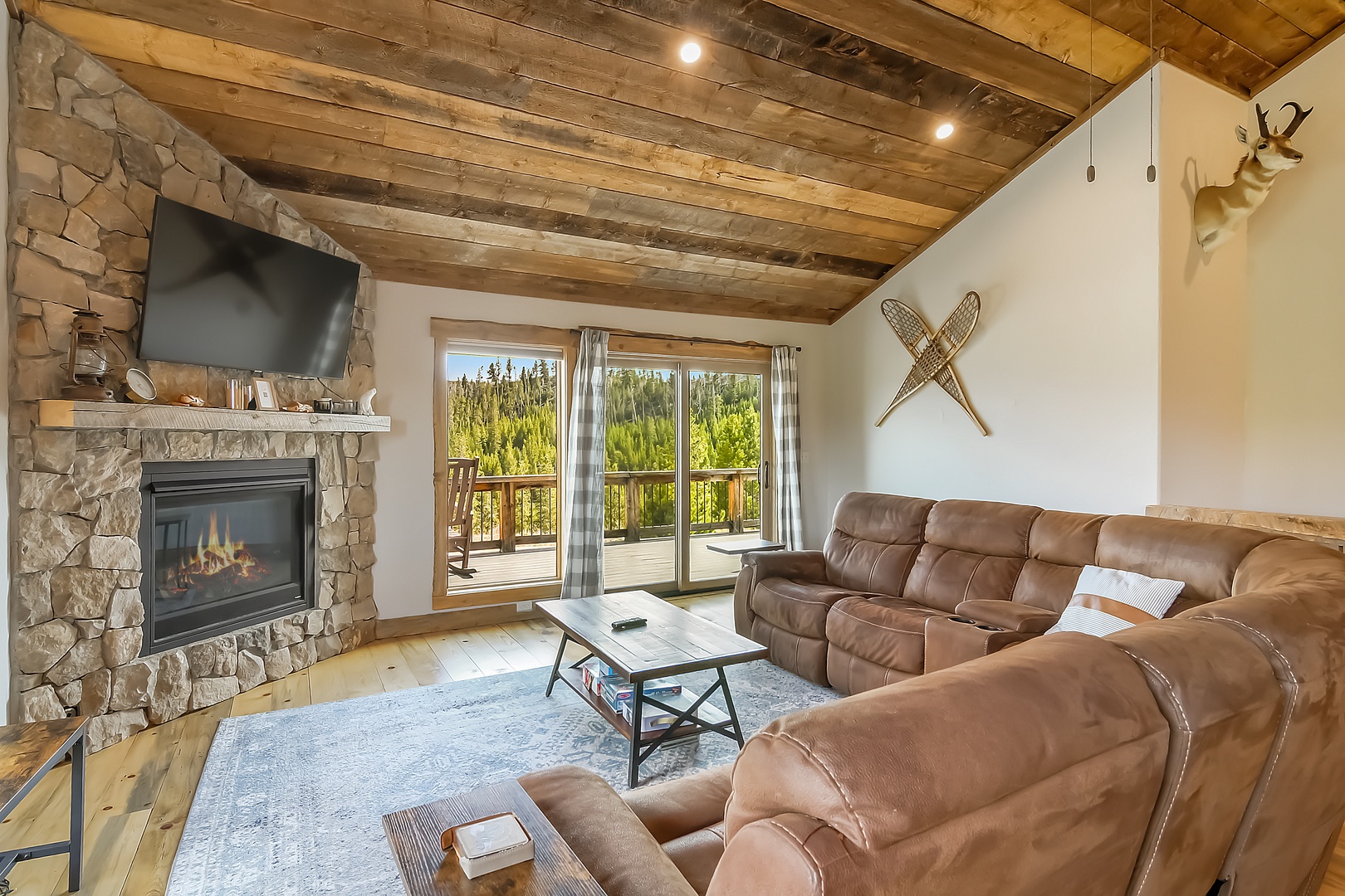 Sink into the plush sectional by your crackling fireplace, where rustic beams and stone surround you in mountain comfort.