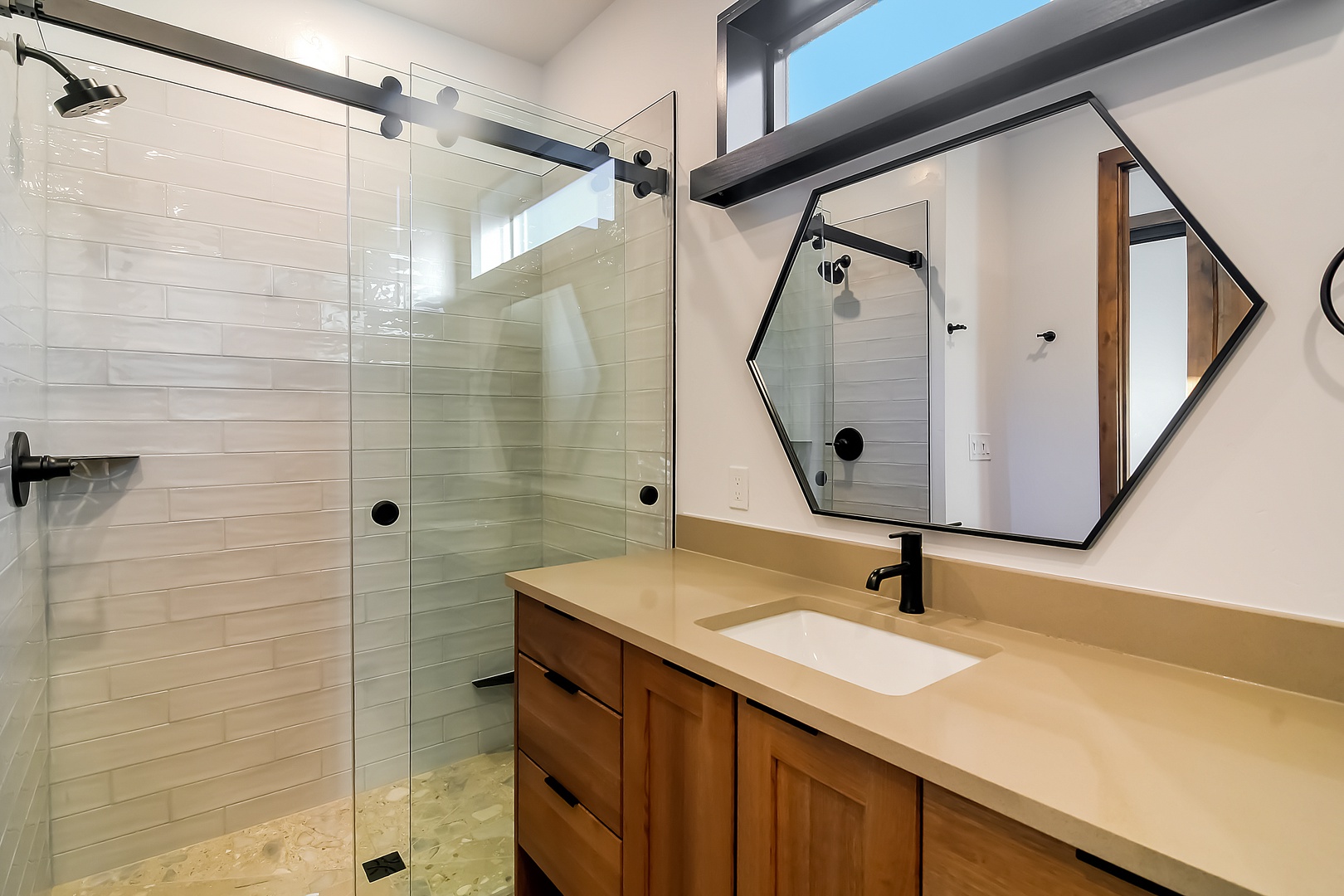 Step into your beautifully appointed bathroom featuring a spacious glass-enclosed shower and elegant vanity, perfect for refreshing after your adventures.