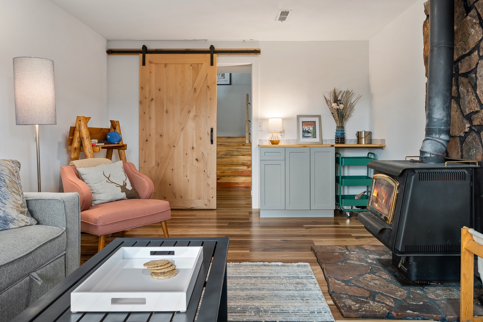 Curl up in your cozy living room where a crackling wood-burning fireplace and warm natural light create the perfect retreat after mountain adventures.