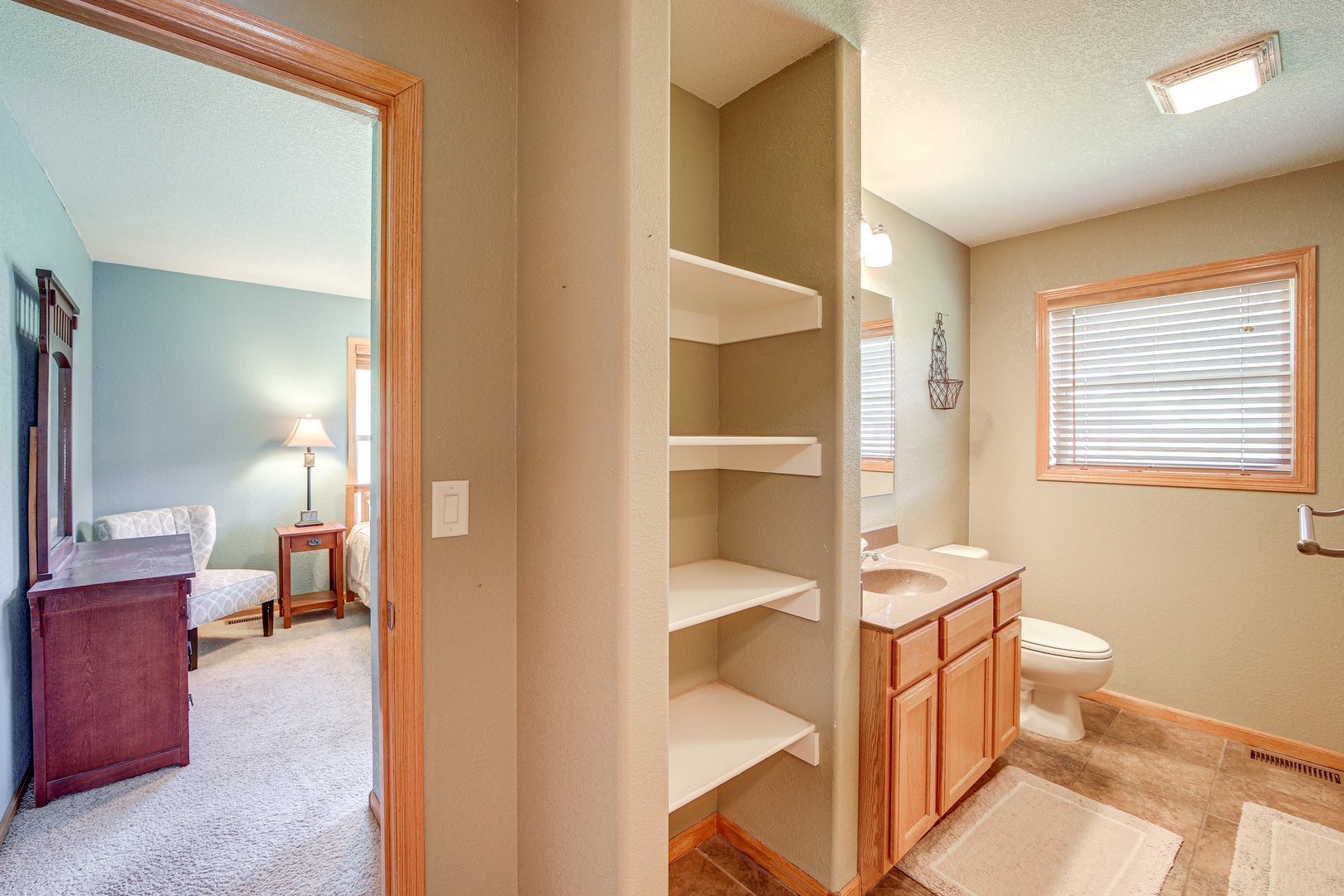 Your private bathroom features built-in shelving for all your belongings, plus a spacious vanity and convenient bedroom access.