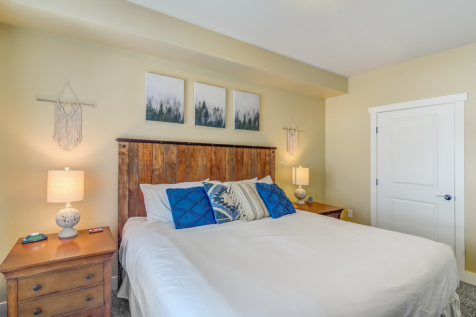 Sink into crisp white linens in your peaceful bedroom, where rustic wood headboard meets modern comfort for perfect mountain retreat dreams.
