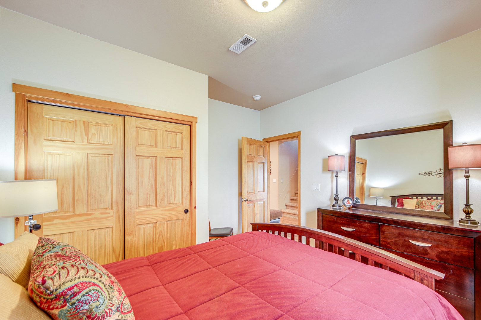 Relax in your spacious bedroom with warm wood details, rich burgundy bedding, and plenty of storage for all your belongings.