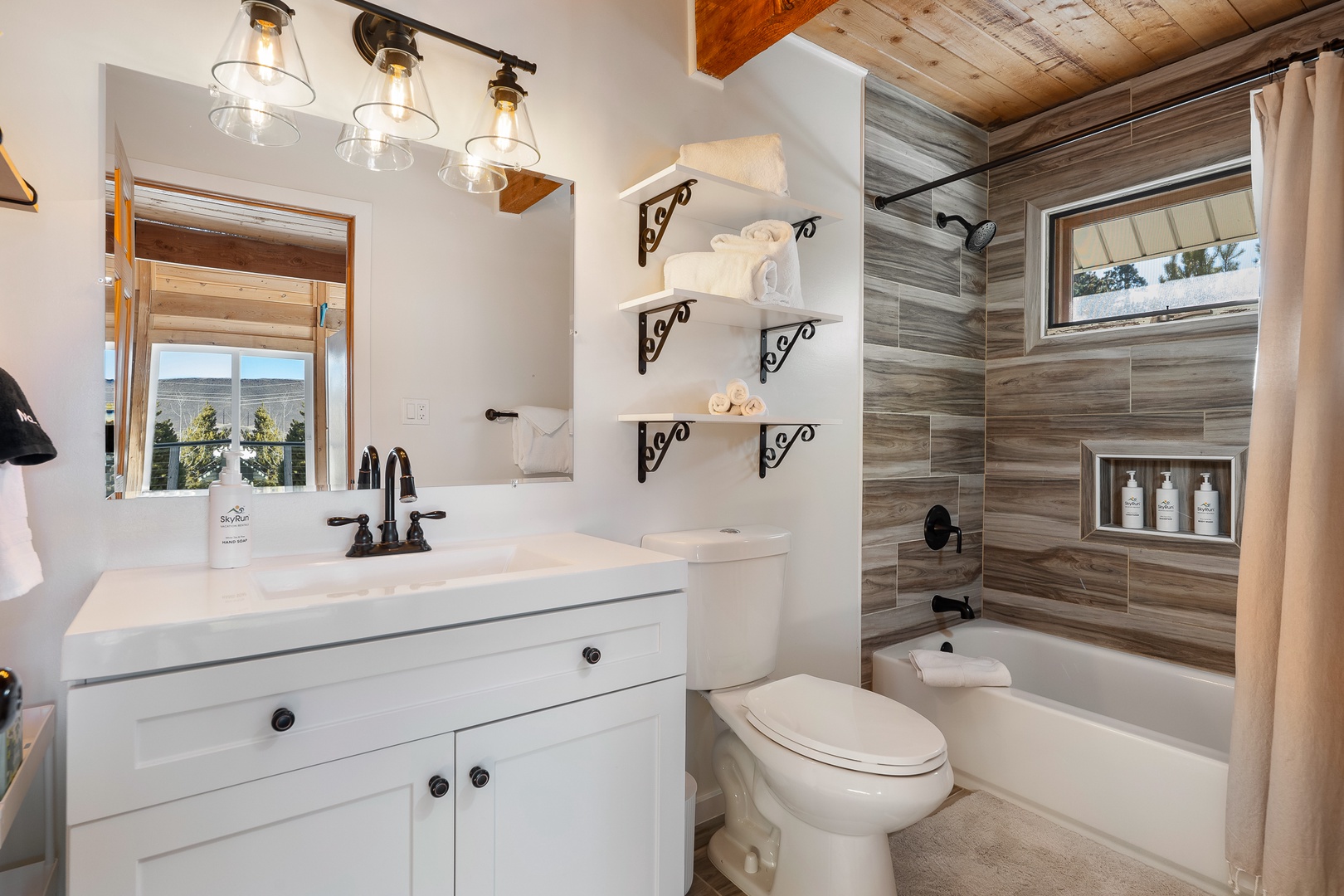 Your private bathroom combines rustic charm with modern comfort, featuring elegant pendant lighting and a relaxing tub-shower combo.