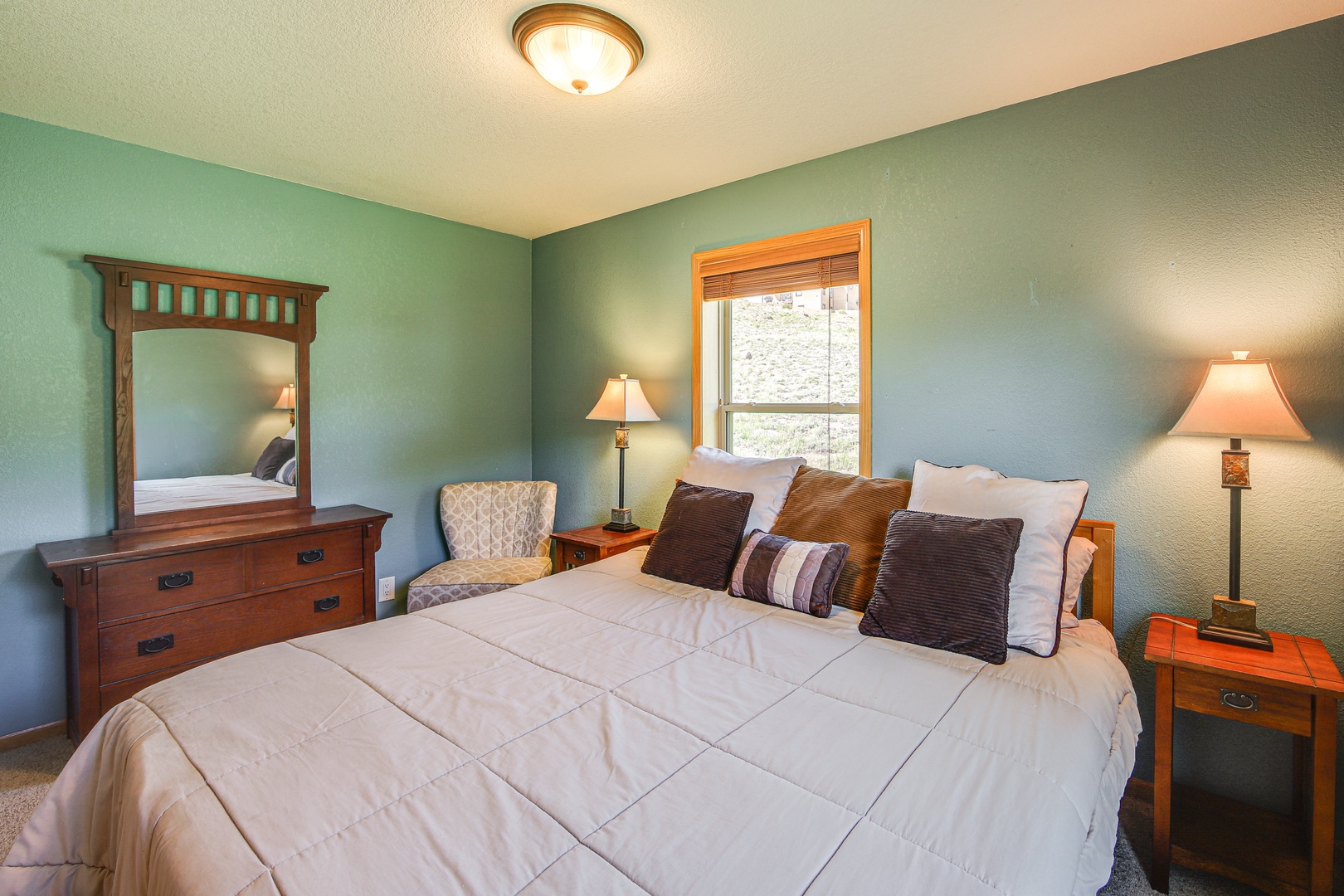 Sink into your comfortable bed surrounded by warm wood furnishings and soothing green walls that create the perfect retreat.