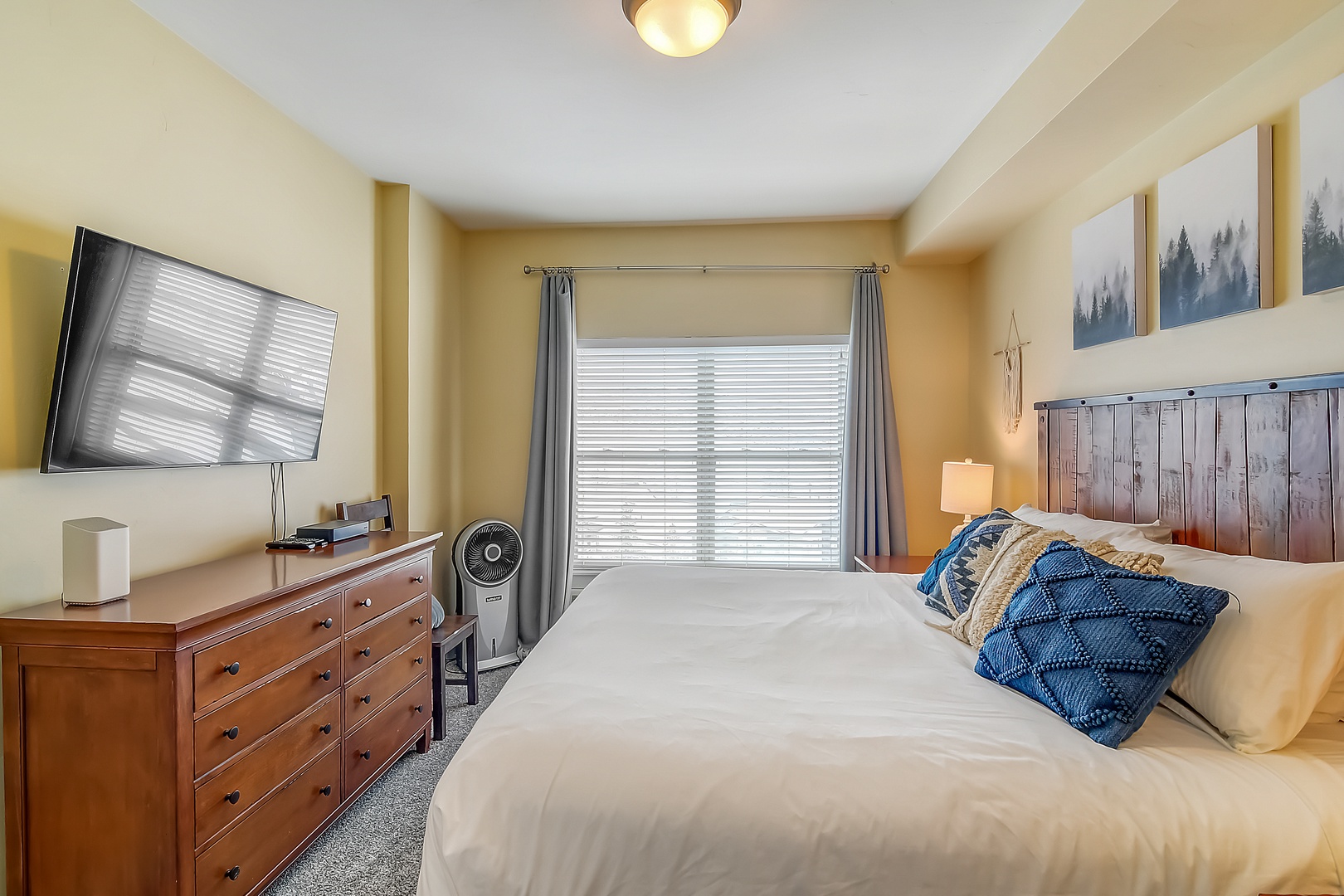 Unwind in your cozy bedroom with rustic wood headboard, plush bedding, and modern amenities for the perfect mountain retreat.