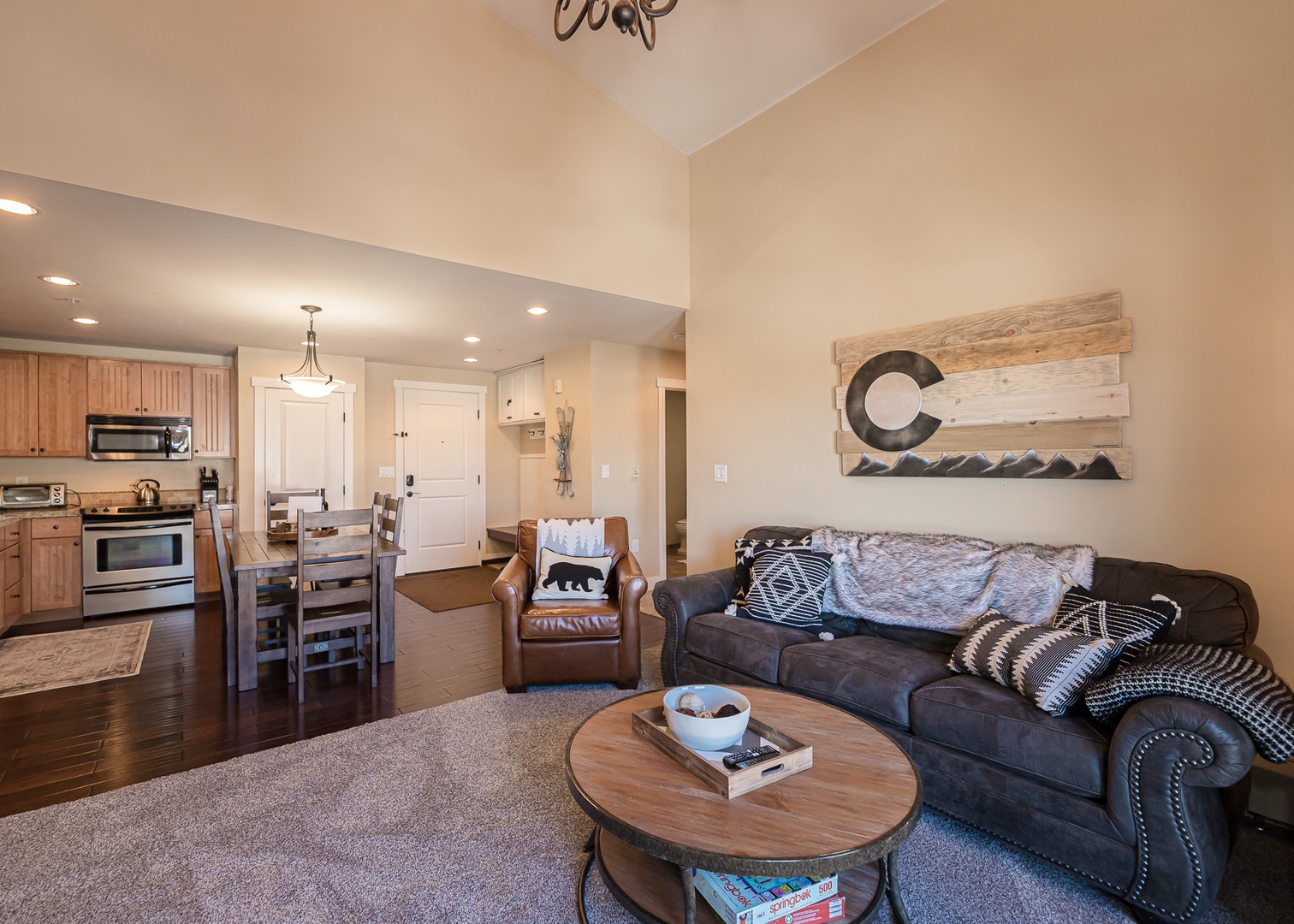 Sink into plush sofas in your open-concept living space, where rustic mountain art meets modern comfort for perfect après-ski relaxation.