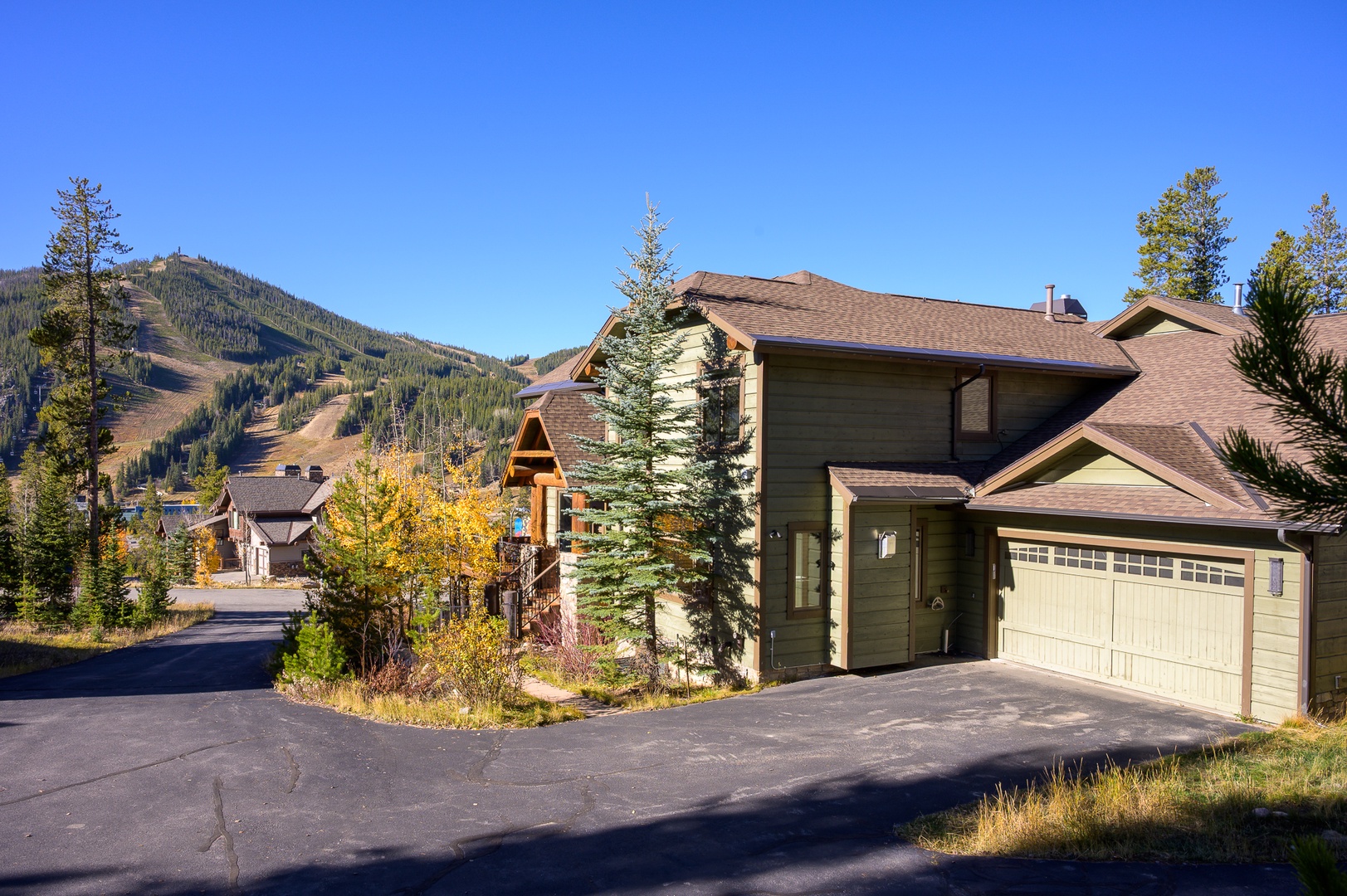 Mountain retreat with ski slopes backdrop and autumn colors surrounding this comfortable home with convenient garage parking.