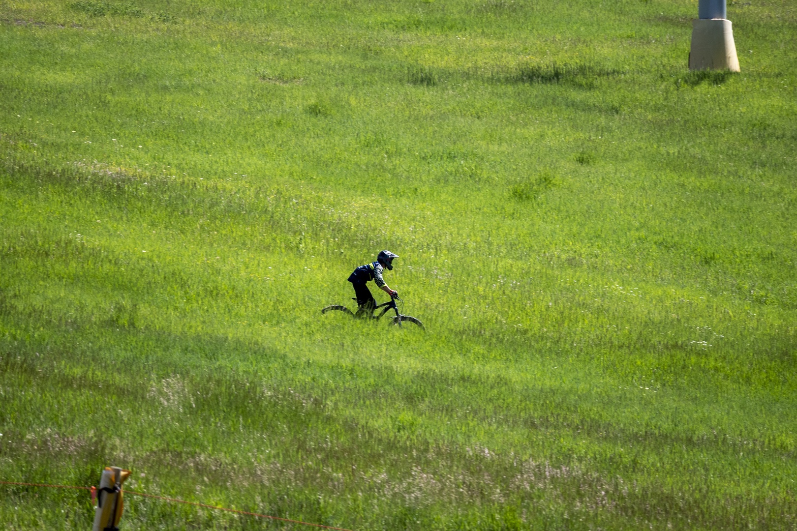 Cyclist enjoying open green fields surrounding the property—ideal for outdoor recreation and fresh air adventures.